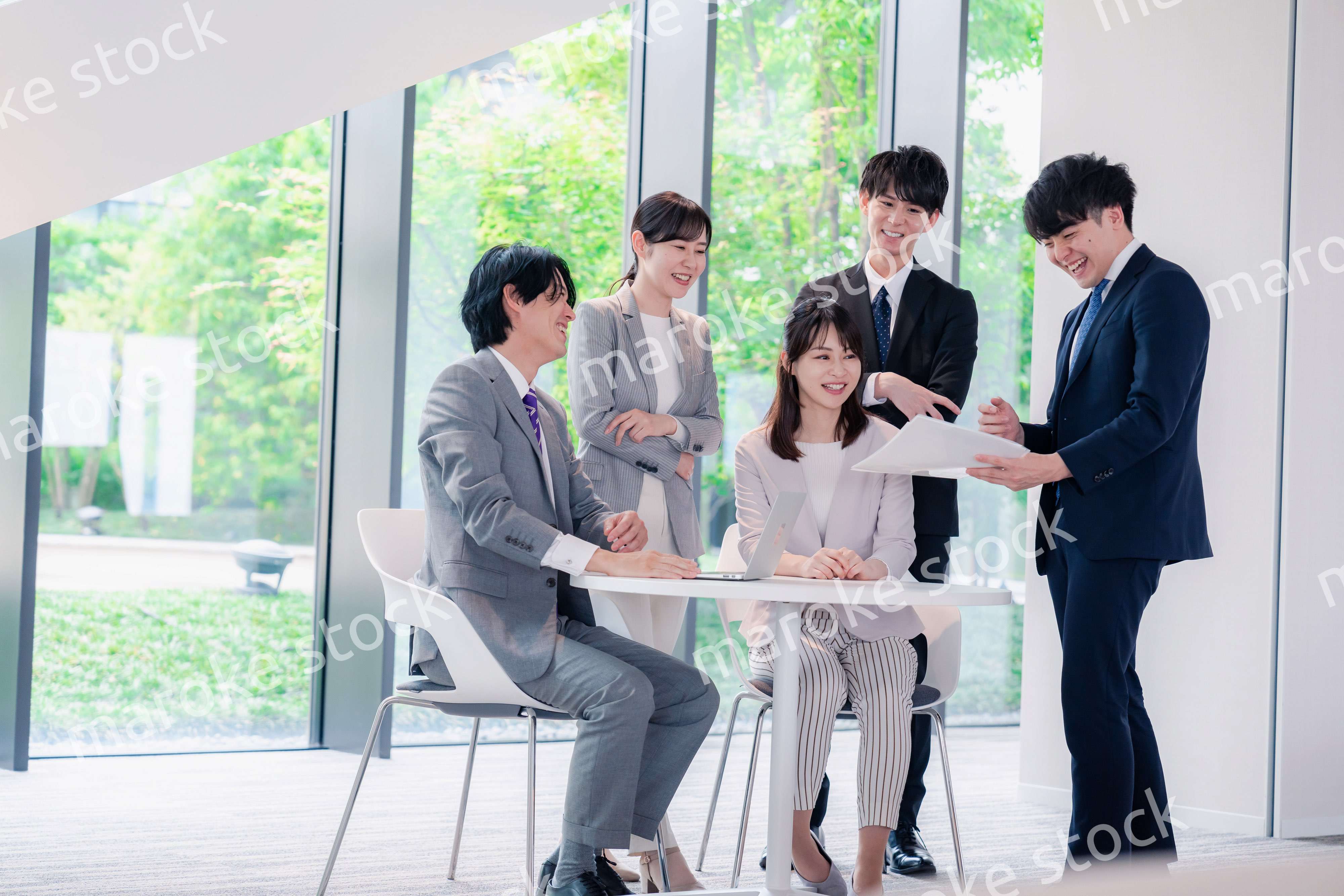 オフィスで笑顔で打ち合わせをするビジネスパーソン