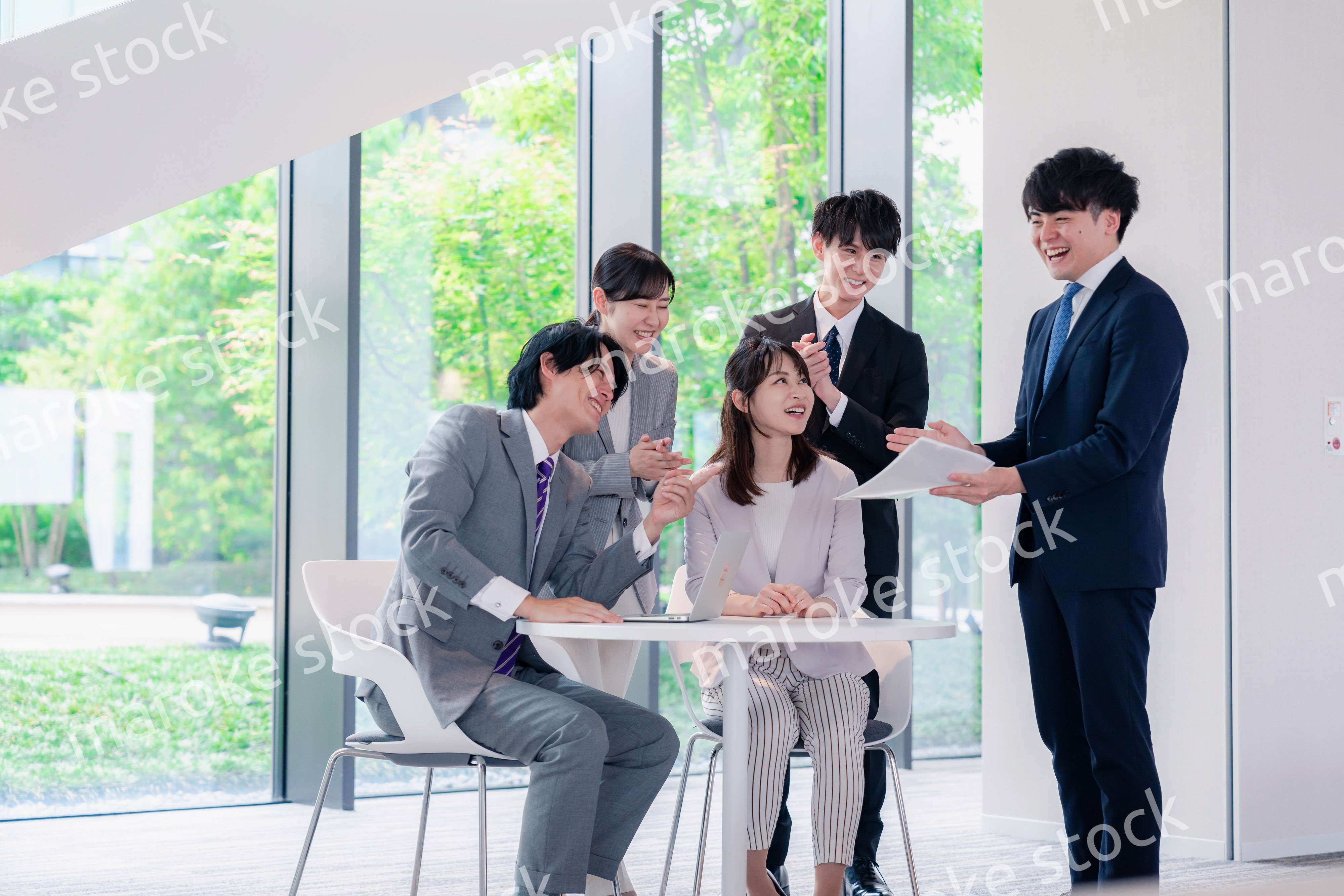 オフィスで笑顔で打ち合わせをするビジネスパーソン