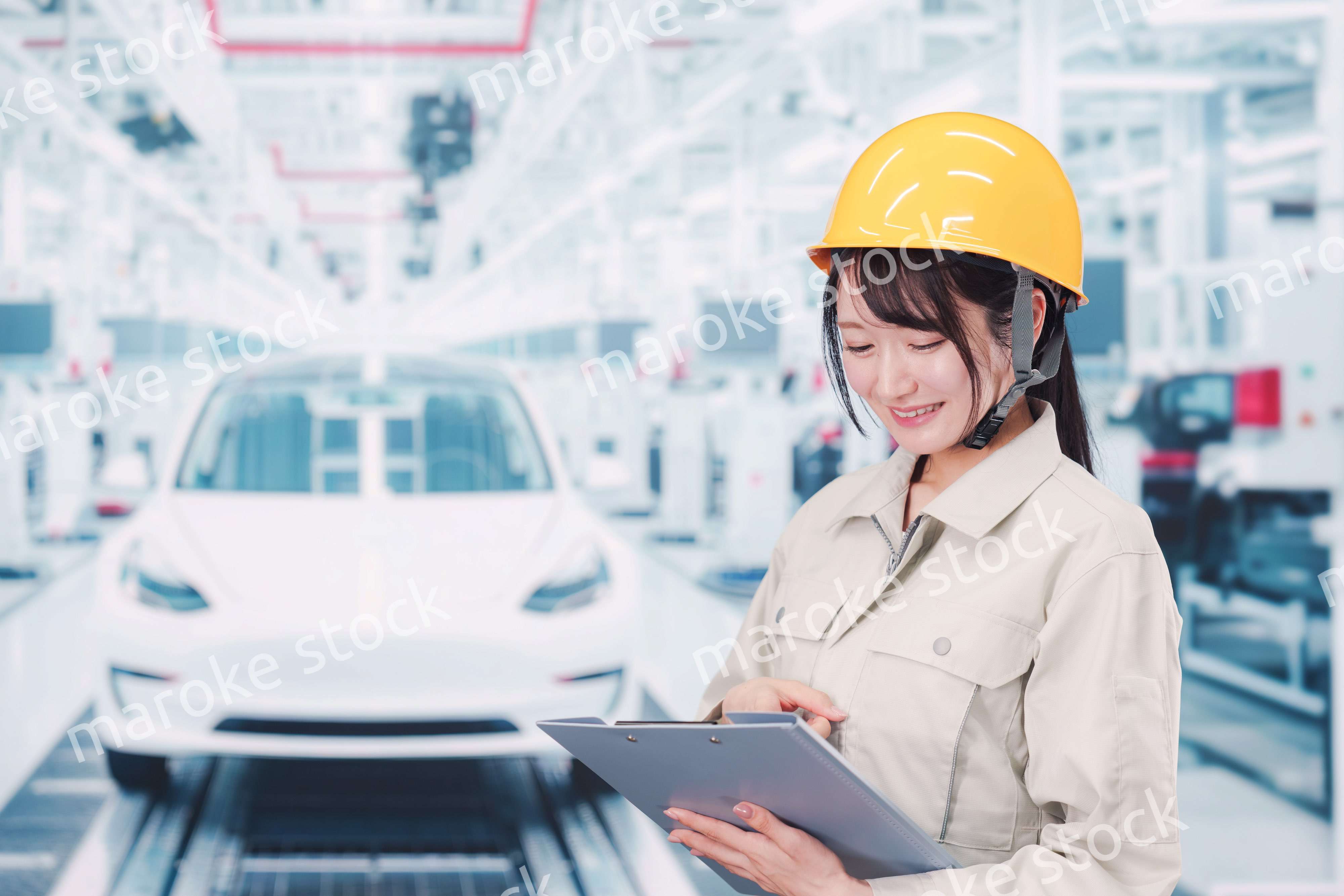 自動車工場の生産ラインで働く若い女性