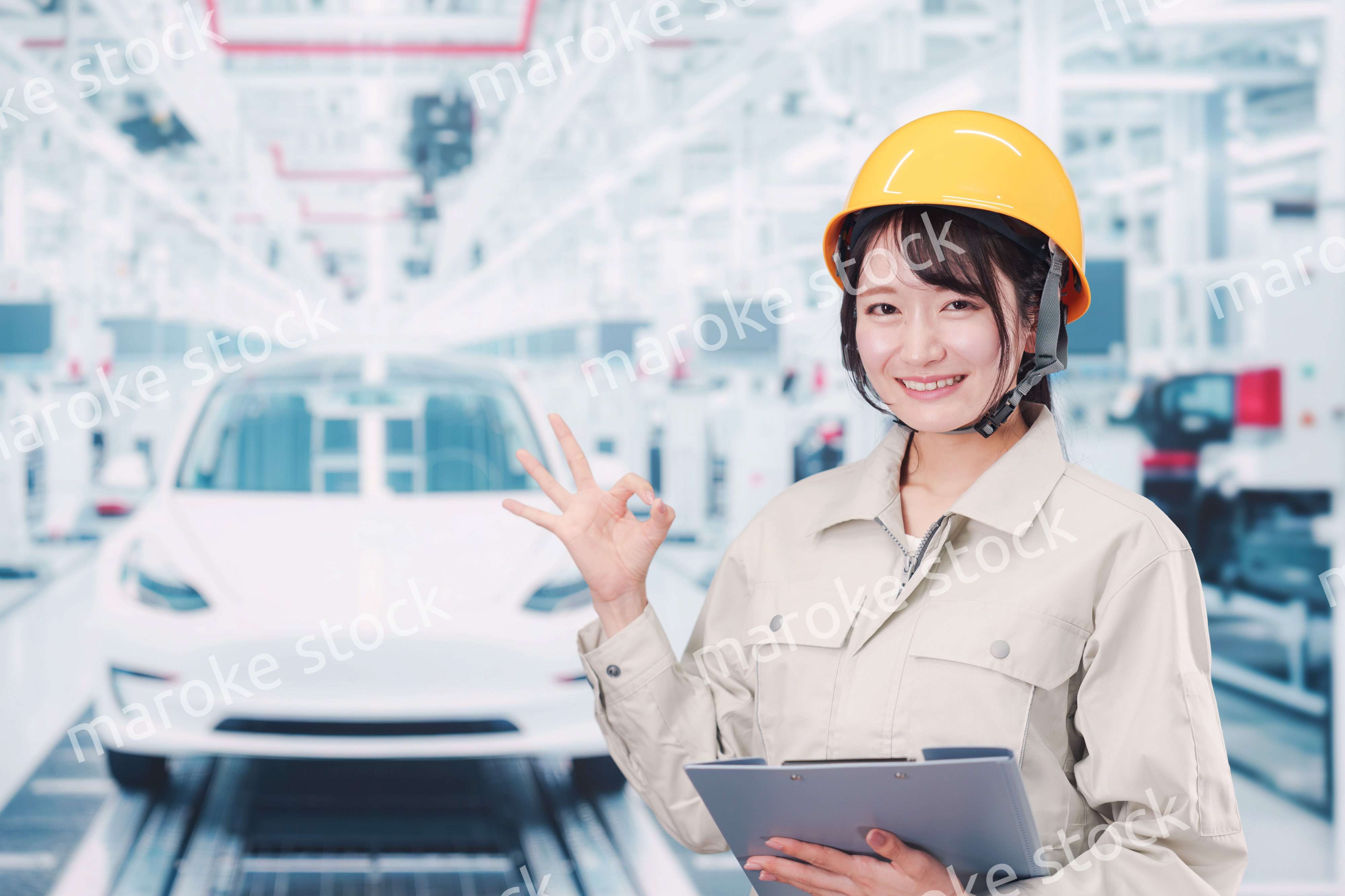 自動車工場の生産ラインで働く若い女性