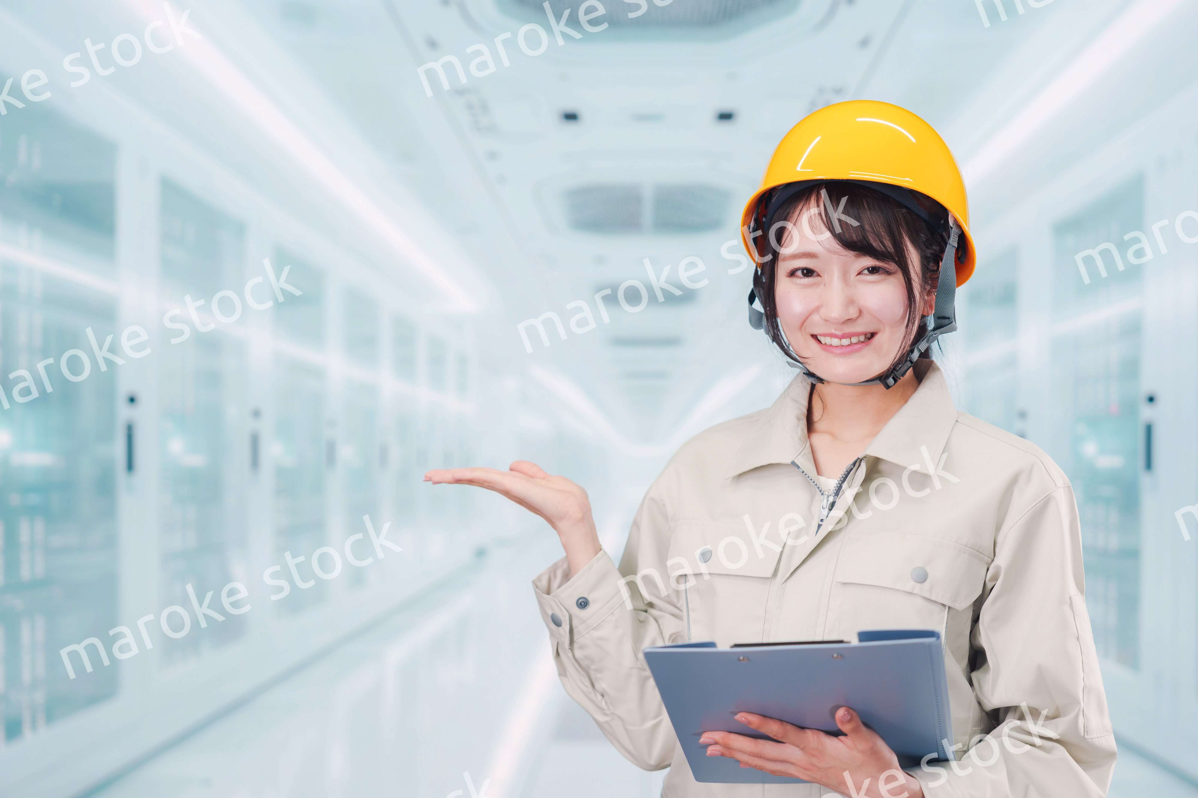 データセンターのサーバールームで働く作業服姿の女性