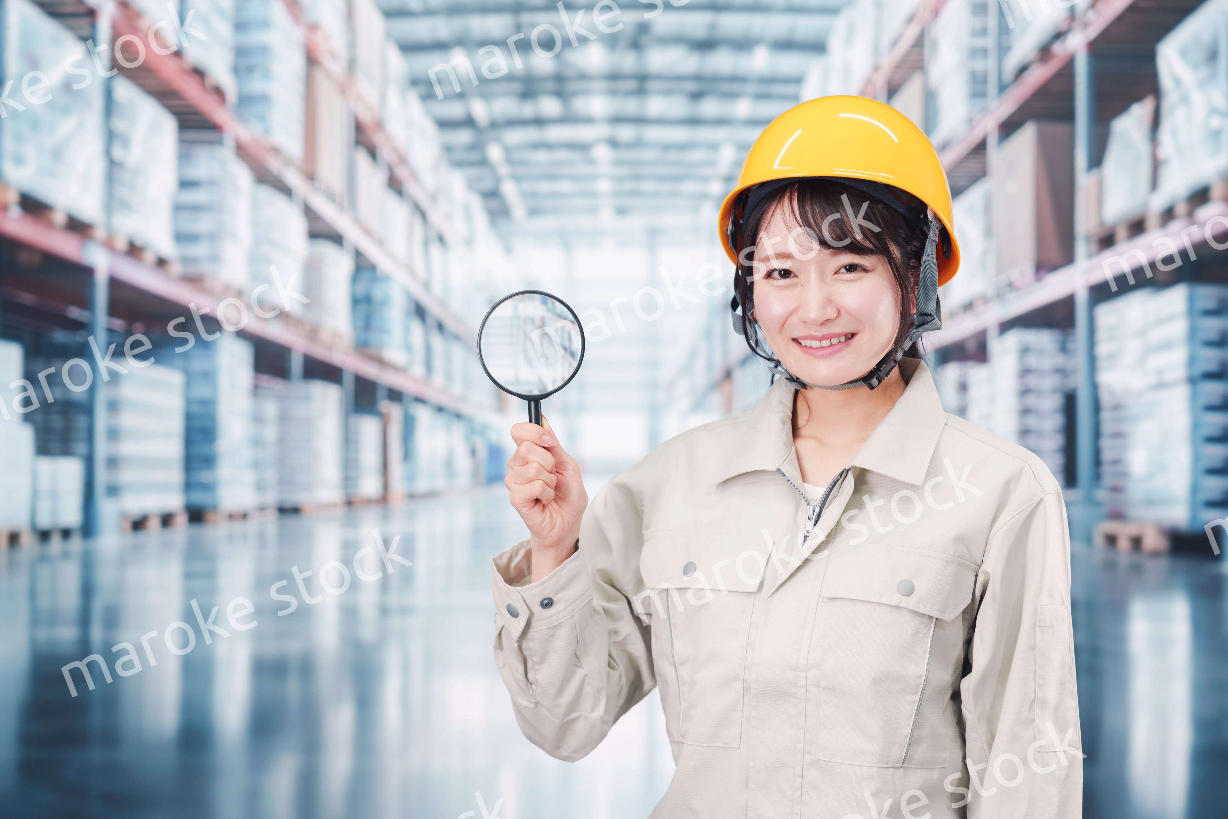 倉庫で在庫を探す作業服姿の女性