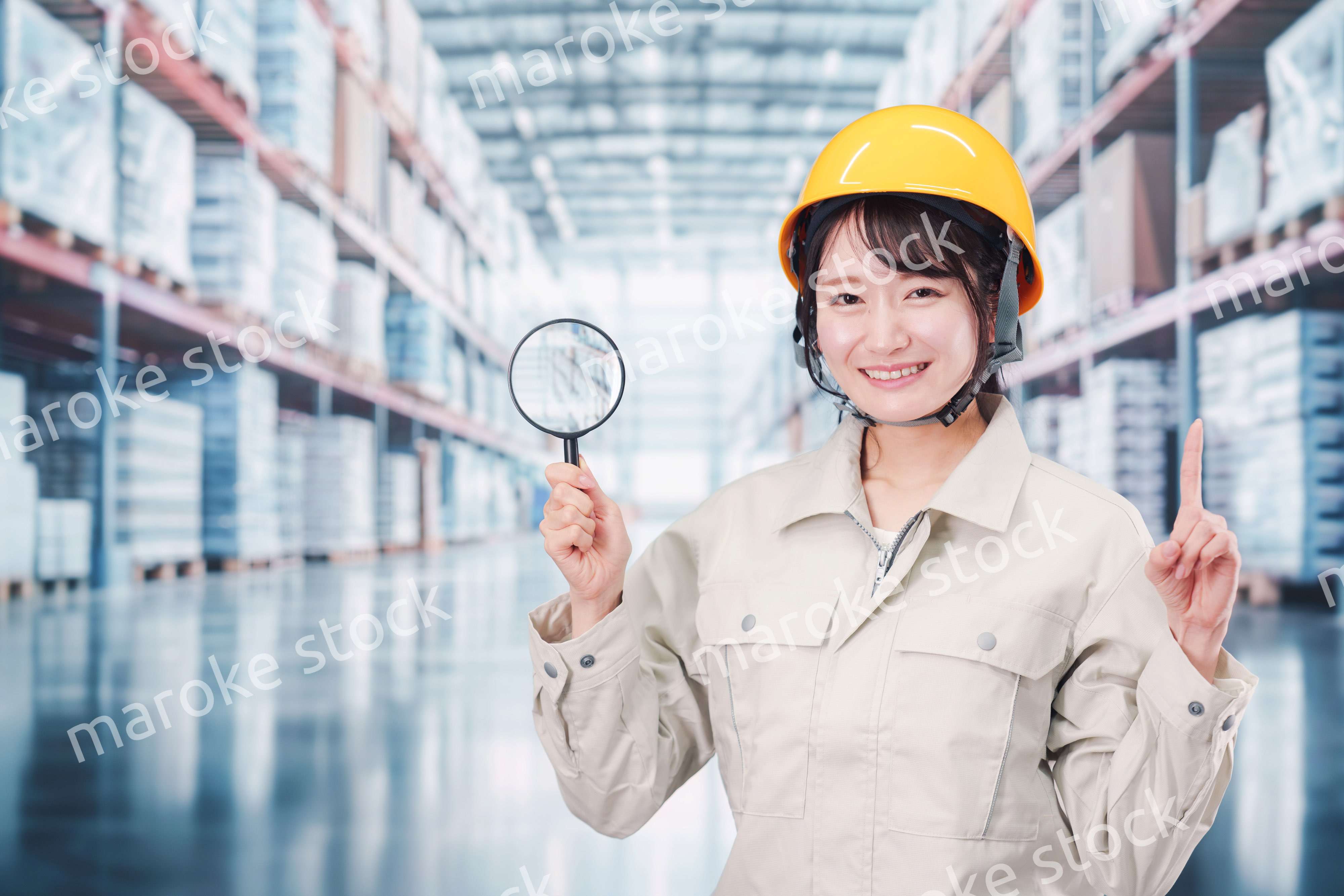 倉庫で在庫を探す作業服姿の女性