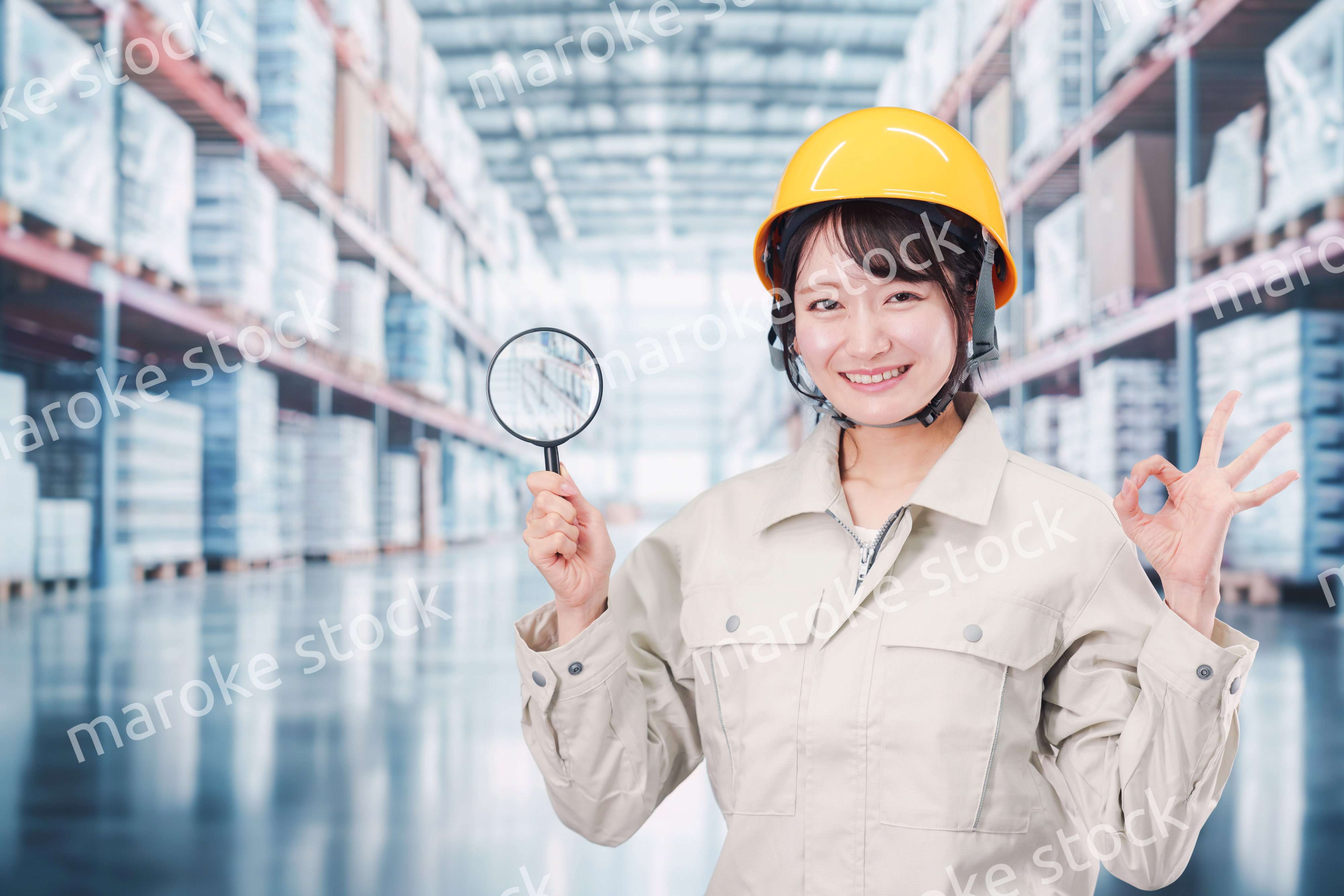 倉庫で在庫を探す作業服姿の女性