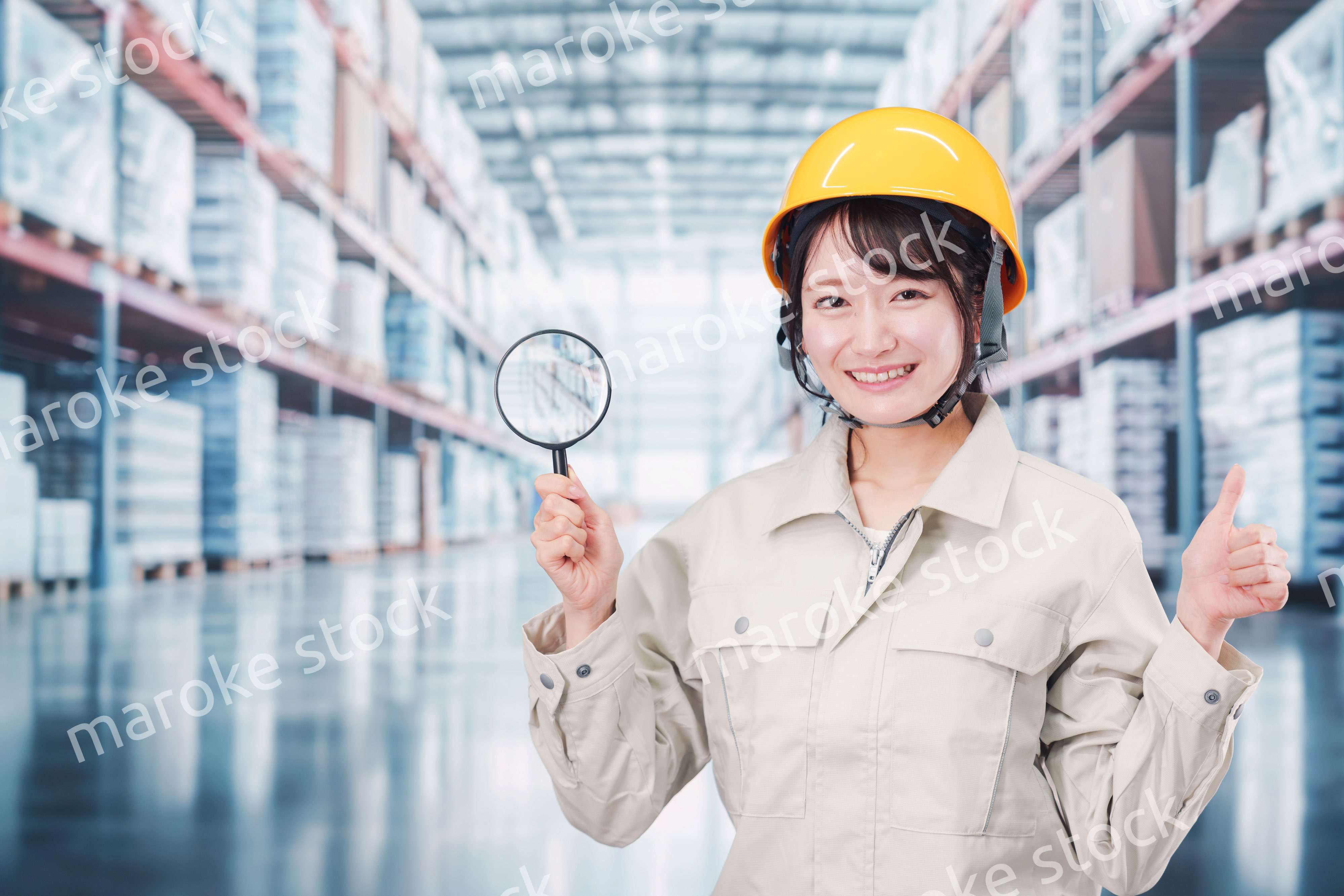 倉庫で在庫を探す作業服姿の女性
