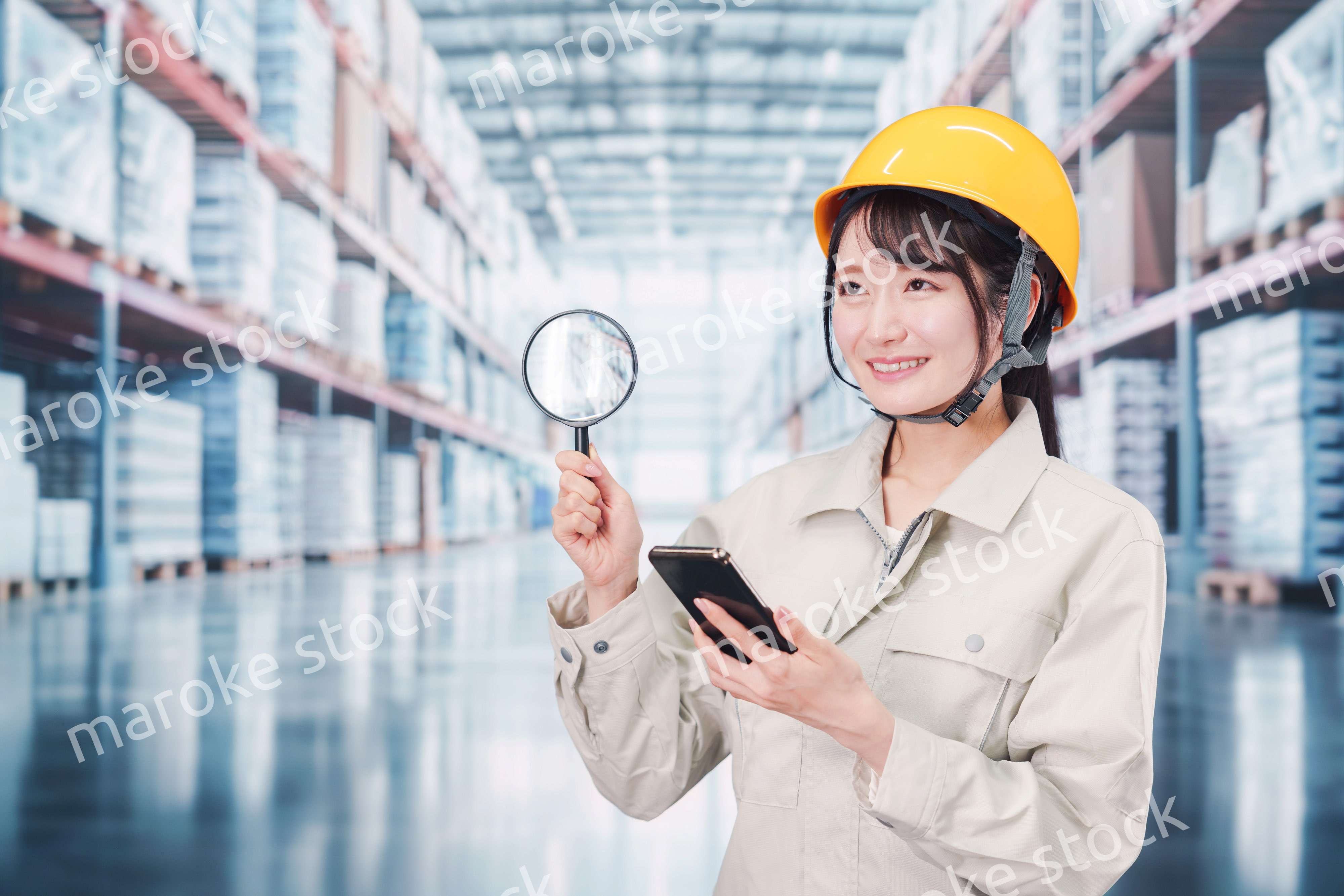 倉庫で在庫を探す作業服姿の女性