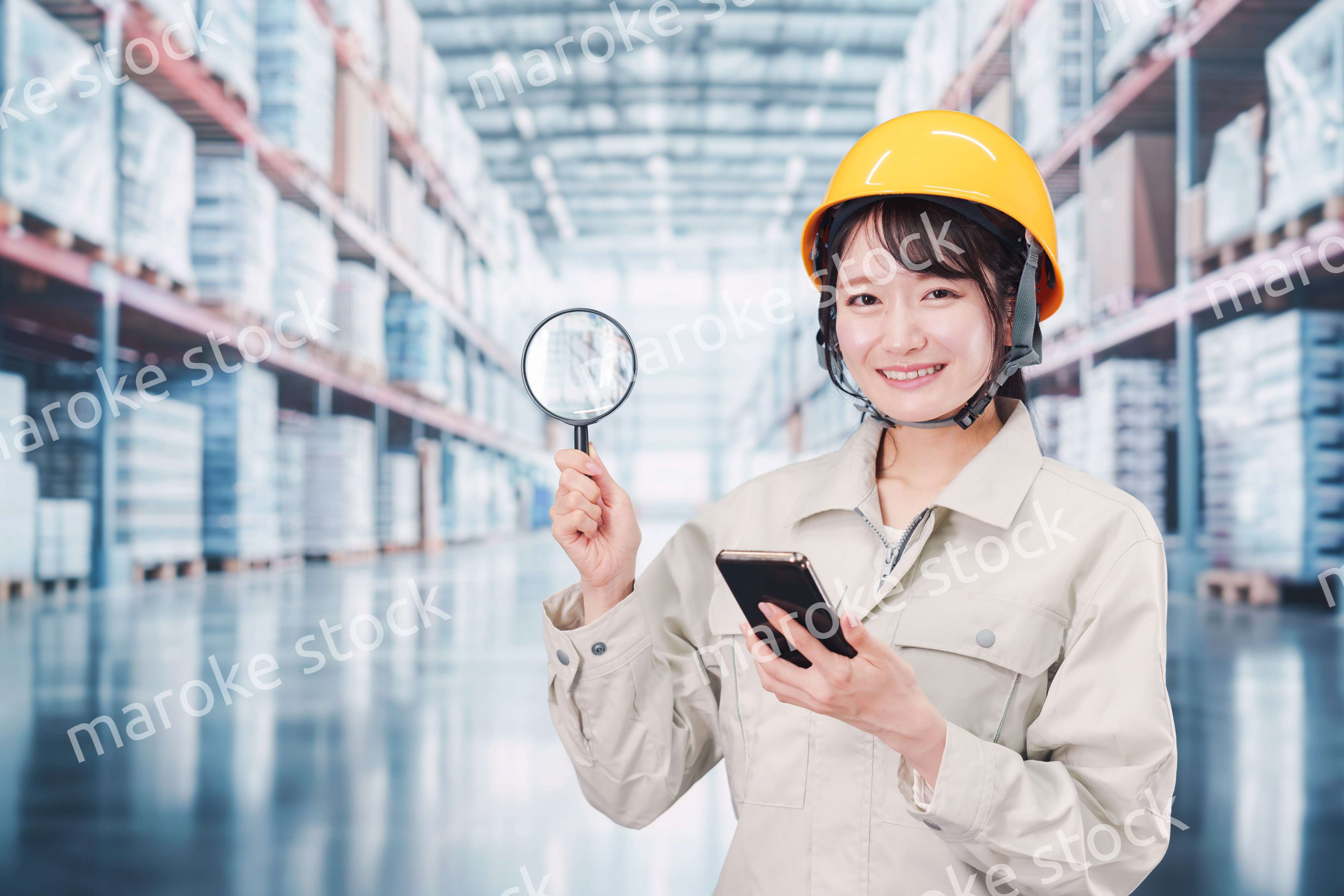 倉庫で在庫を探す作業服姿の女性