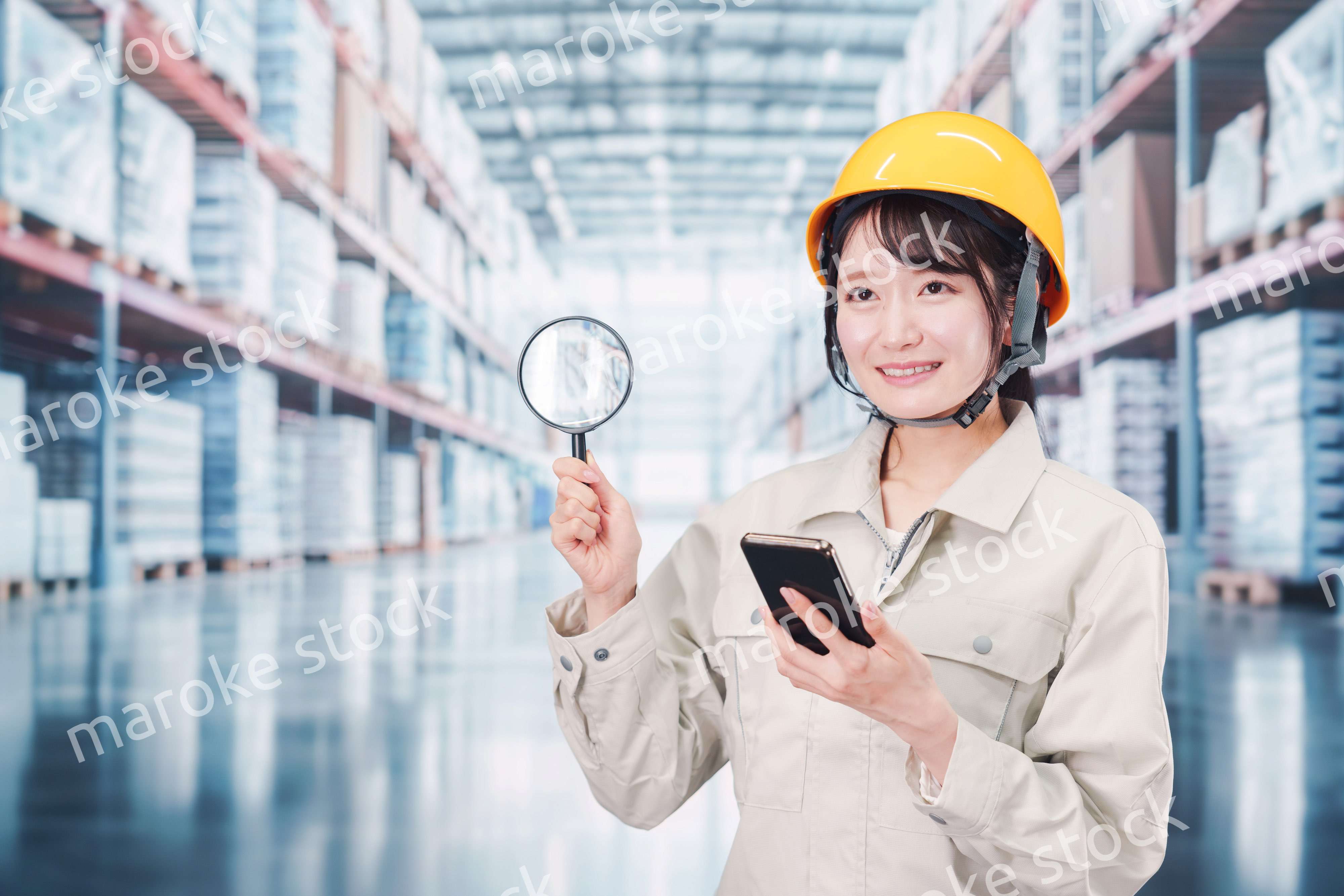 倉庫で在庫を探す作業服姿の女性