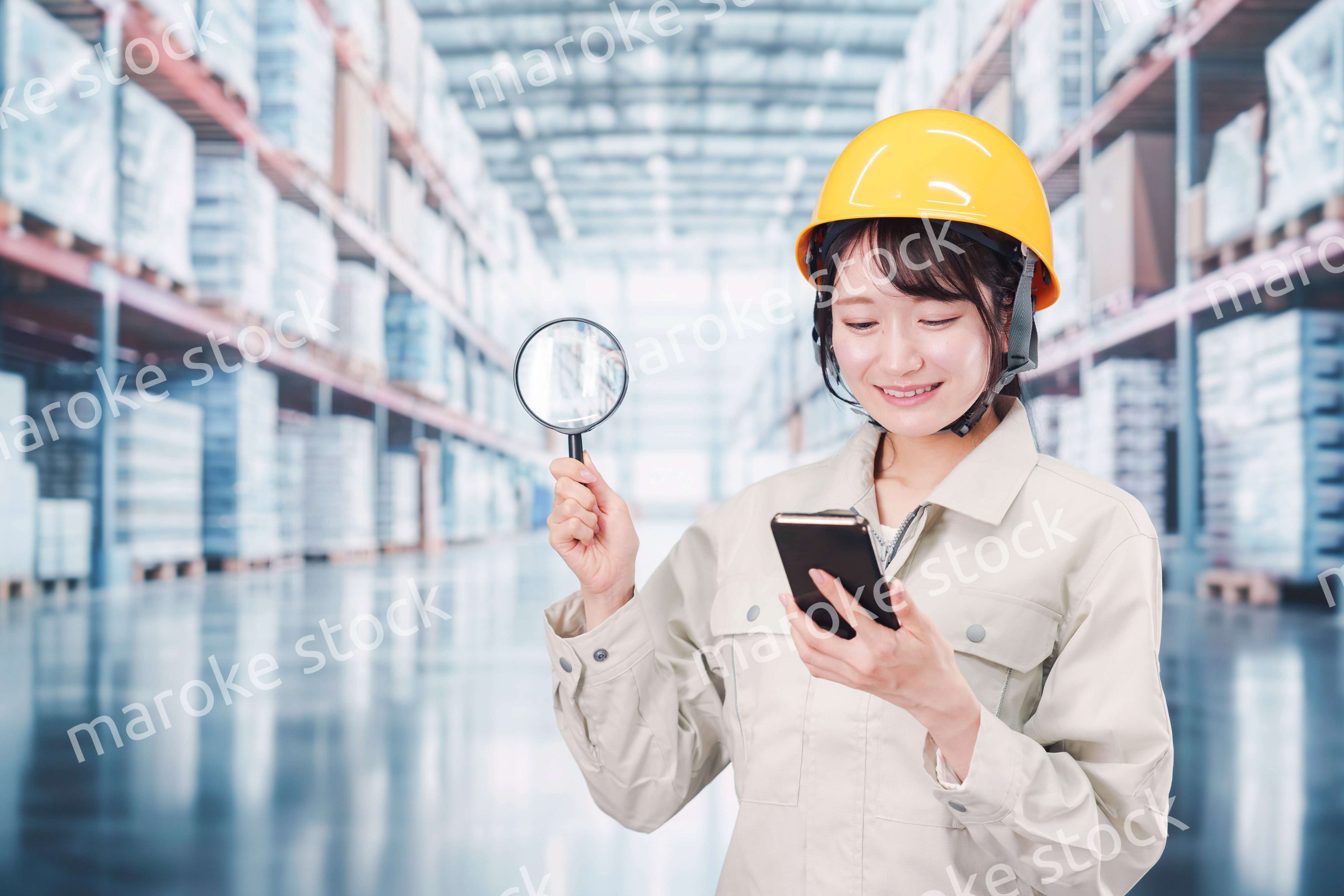 倉庫で在庫を探す作業服姿の女性