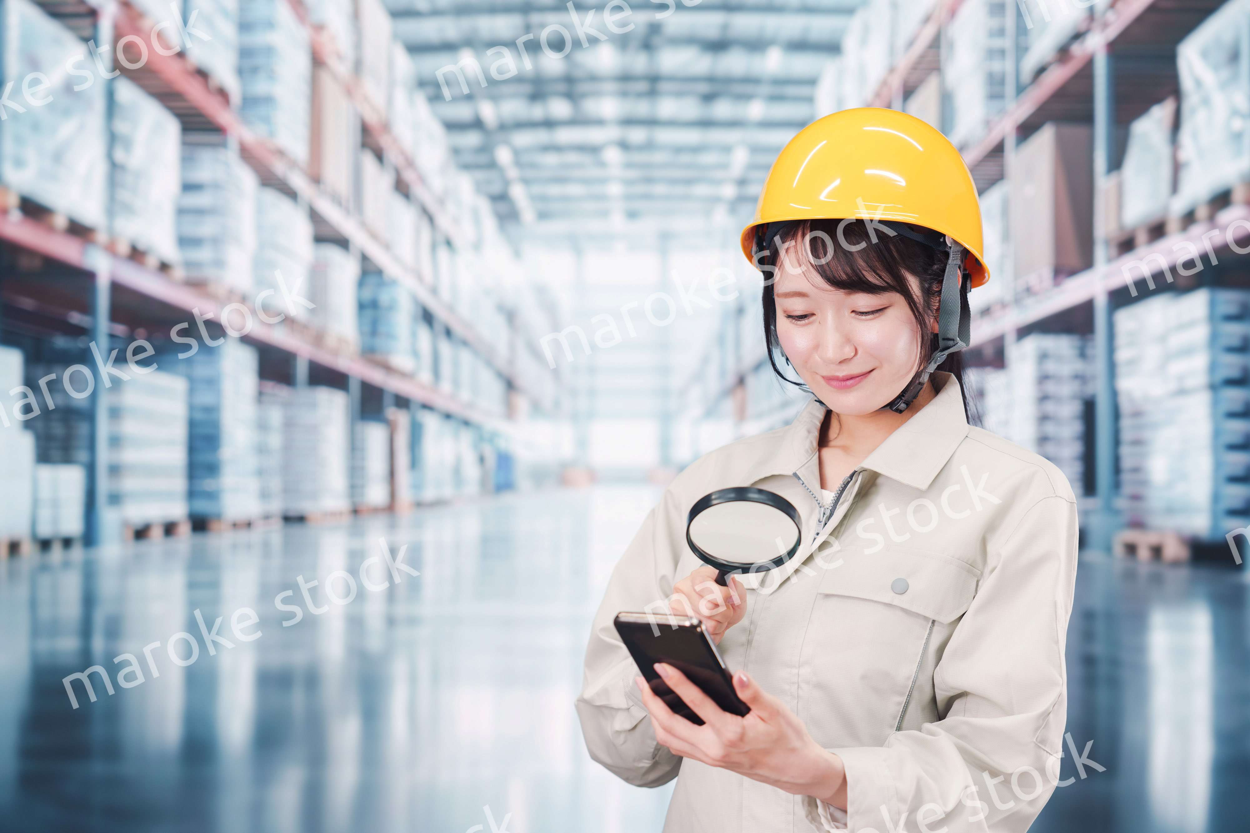 倉庫で在庫を探す作業服姿の女性