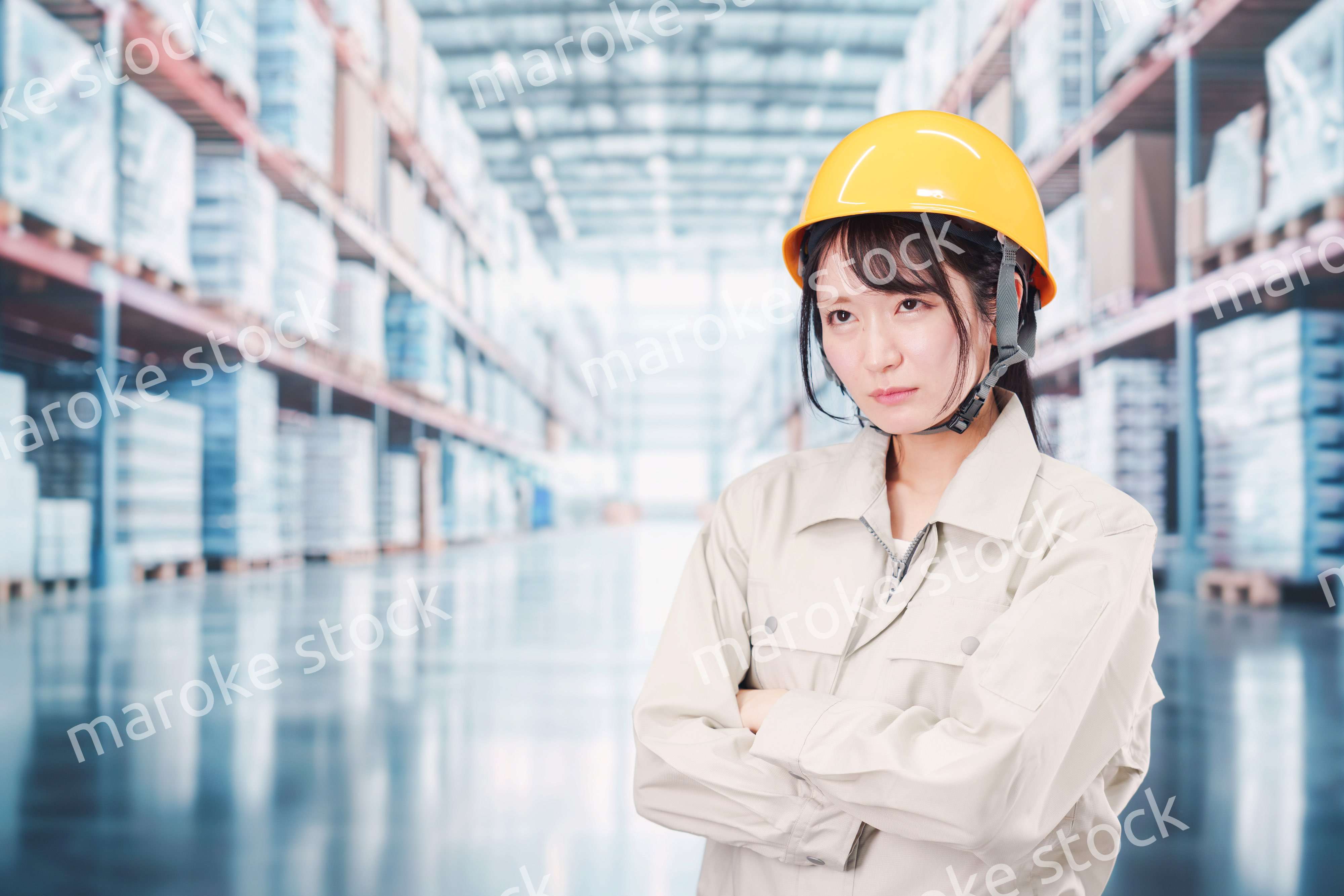 倉庫の中で頭を抱える女性の従業員