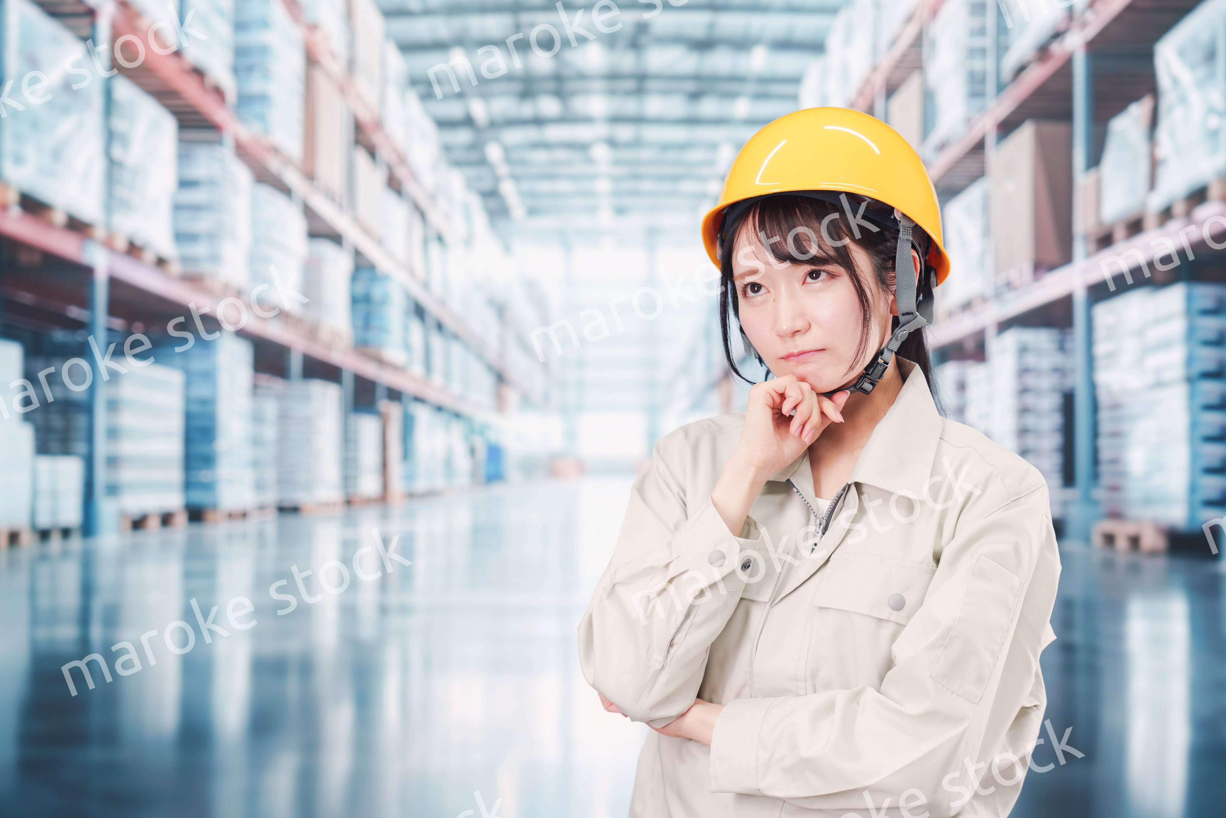 倉庫の中で頭を抱える女性の従業員