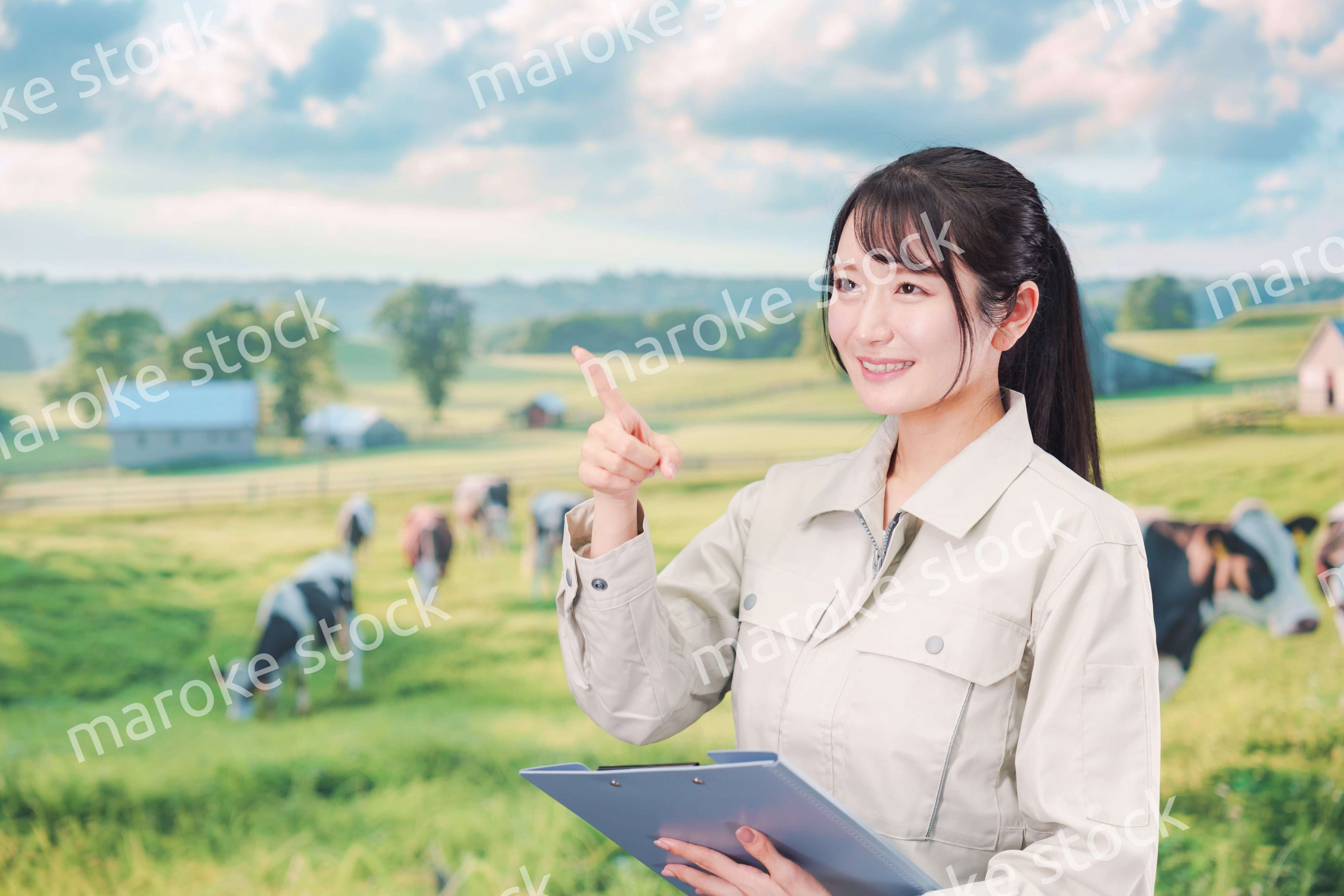 牧場で働く作業服姿の若い女性