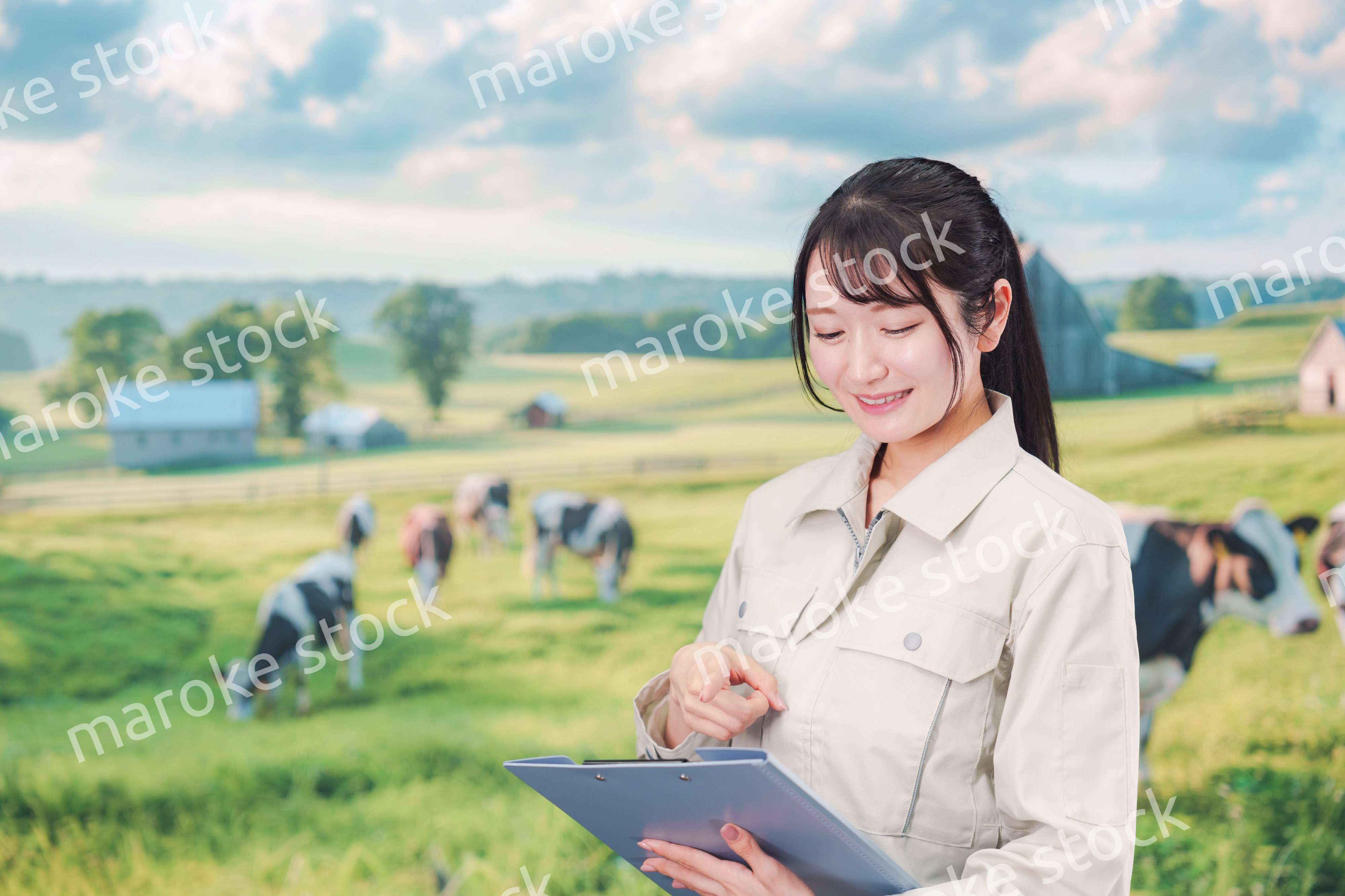 牧場で働く作業服姿の若い女性