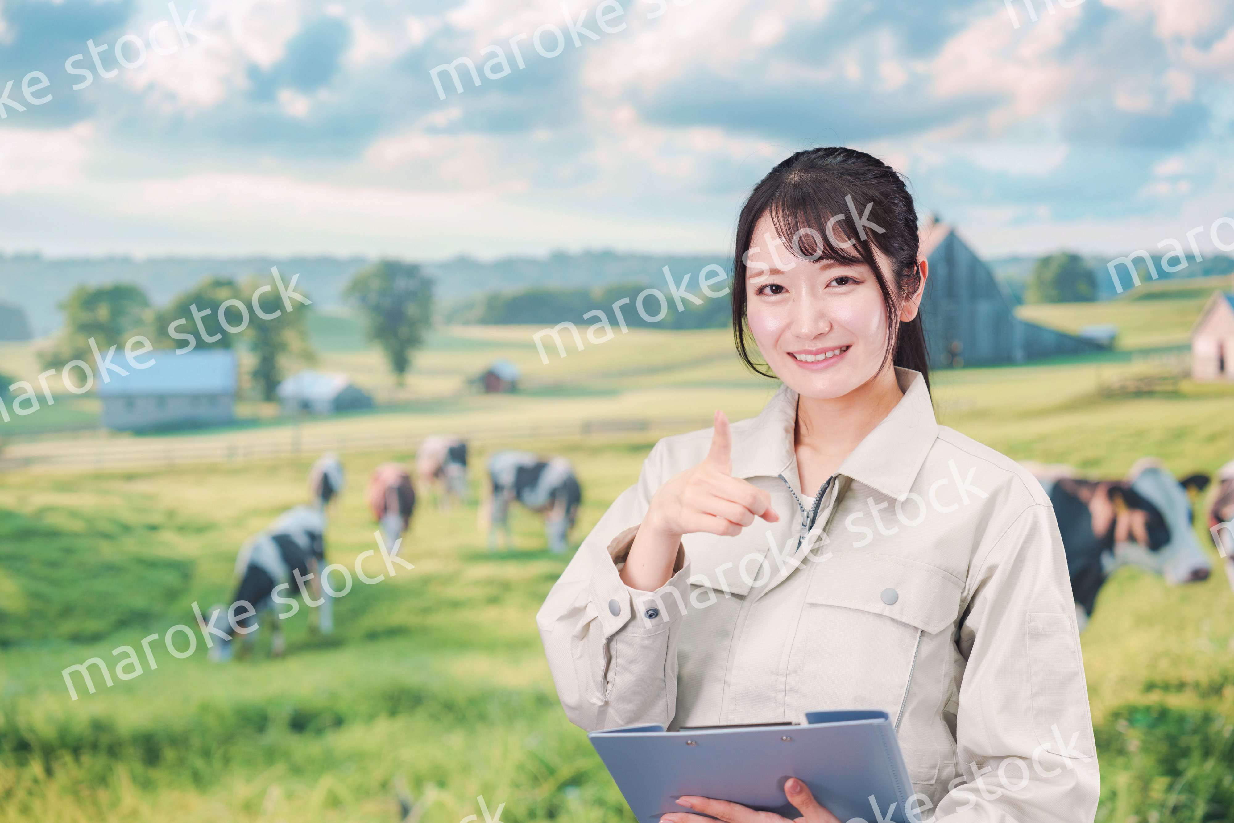 牧場で働く作業服姿の若い女性