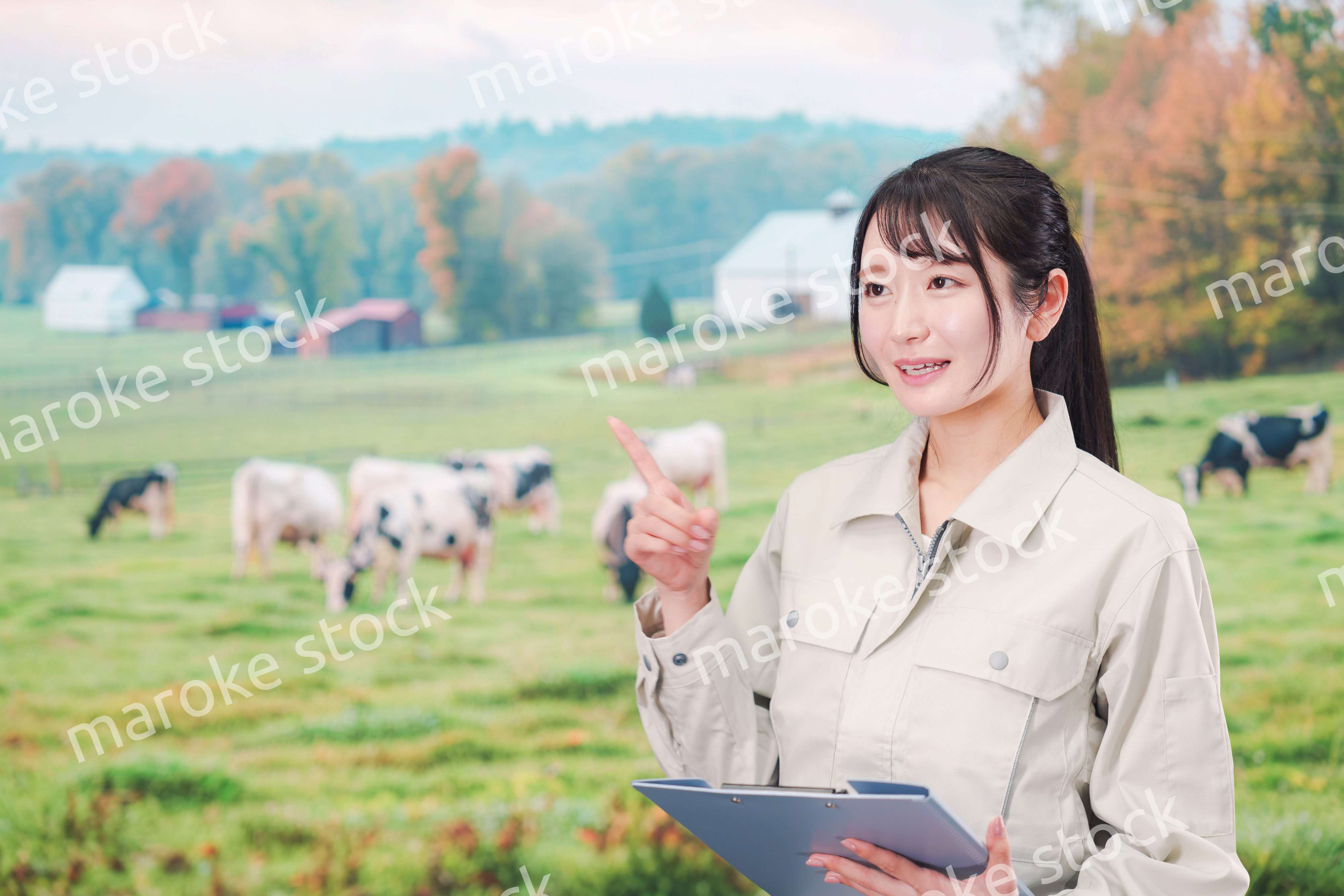 牧場で働く作業服姿の若い女性