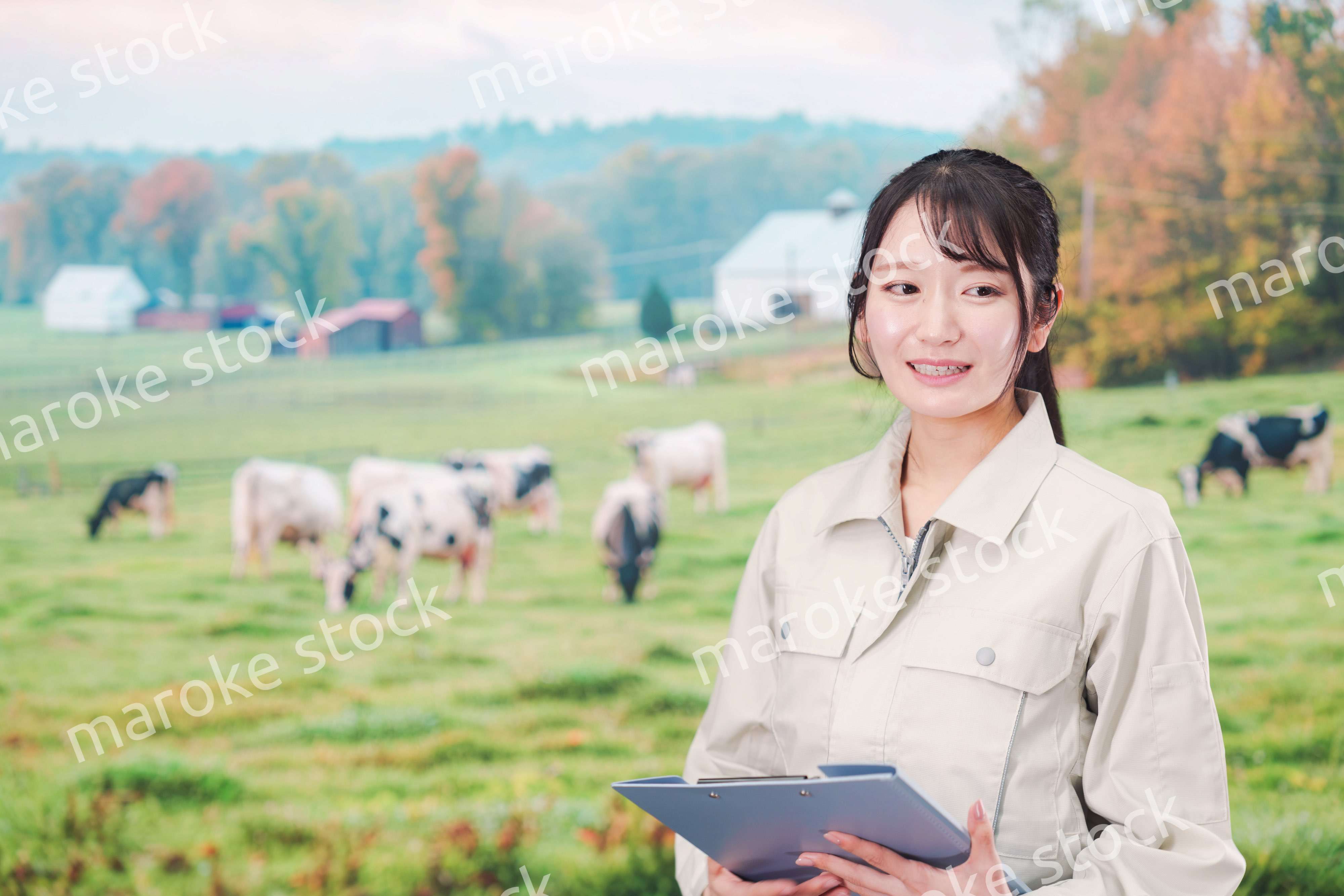 牧場で働く作業服姿の若い女性