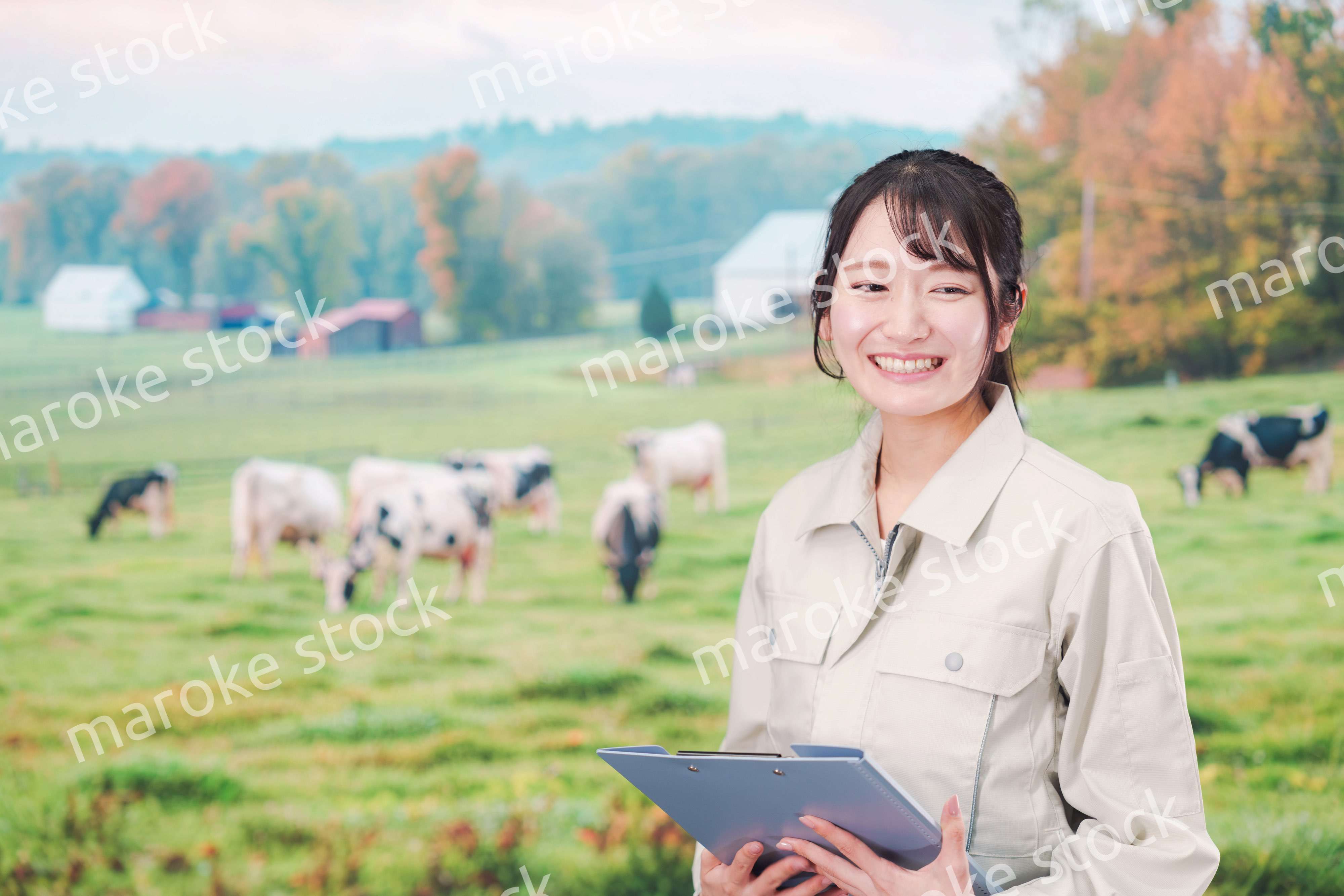 牧場で働く作業服姿の若い女性