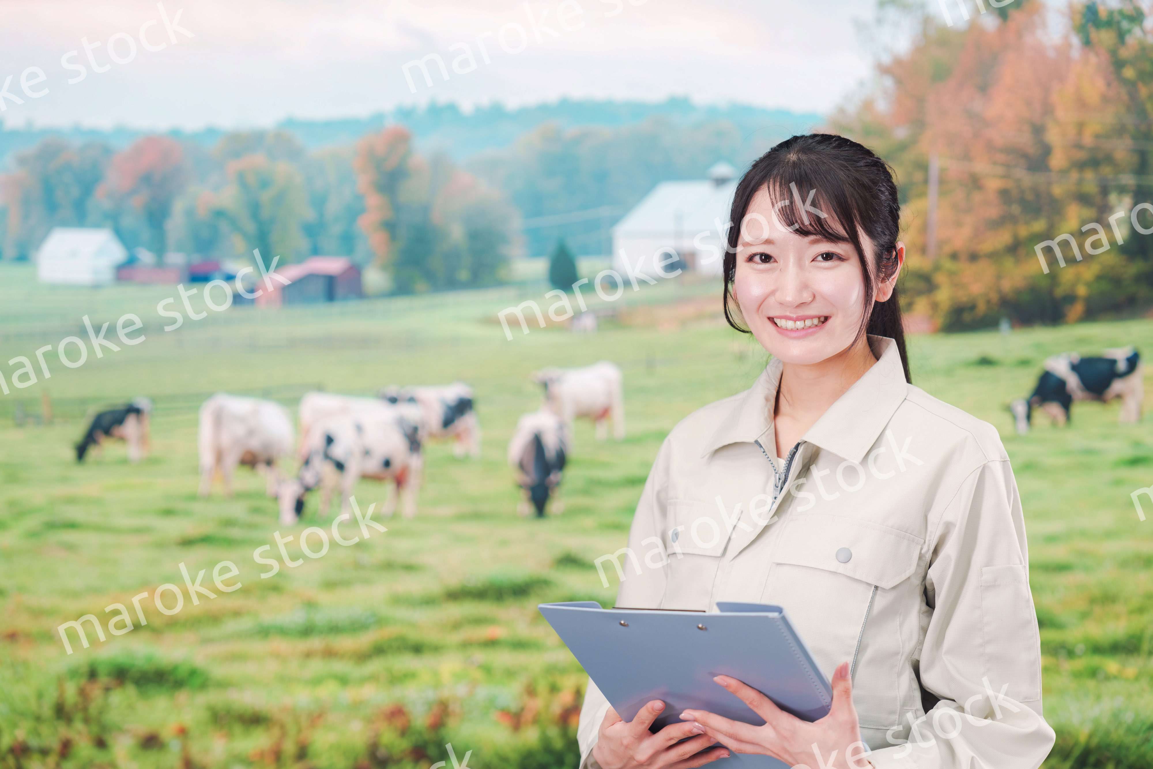 牧場で働く作業服姿の若い女性