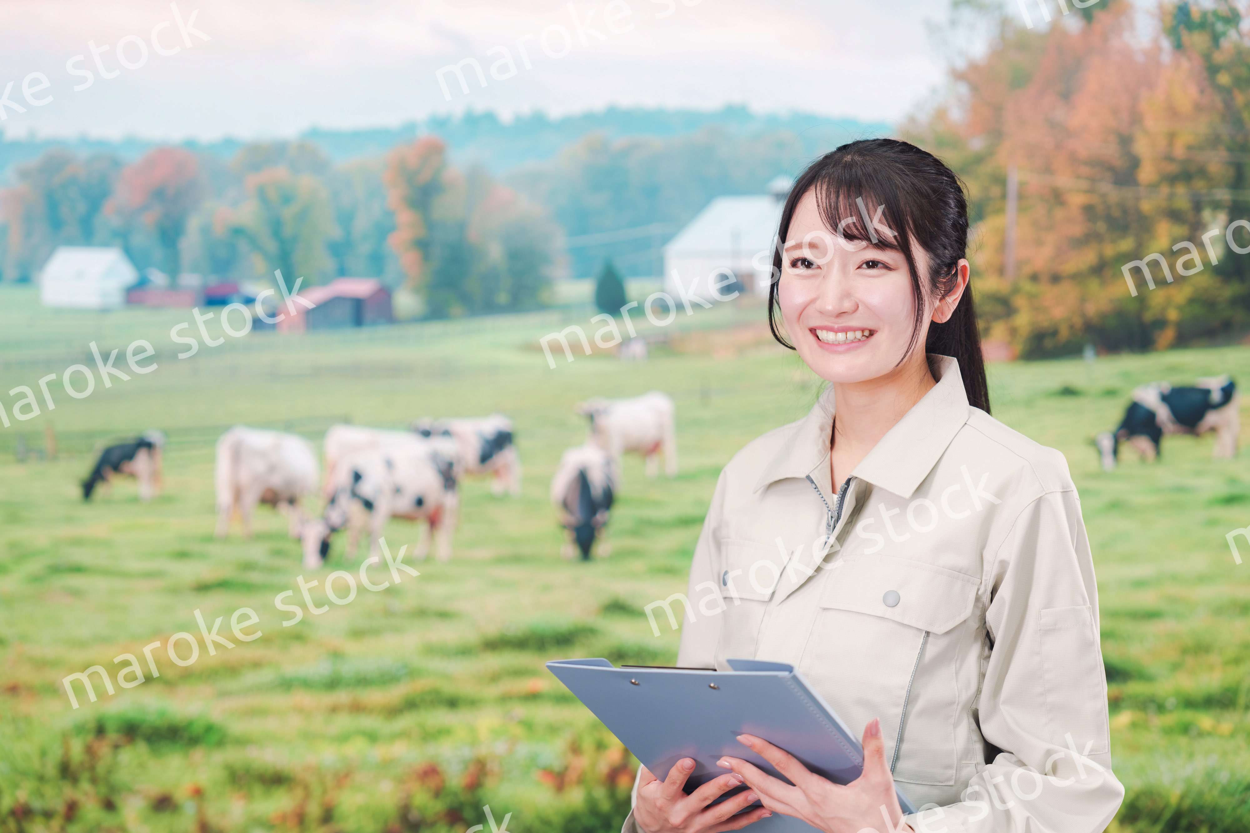 牧場で働く作業服姿の若い女性