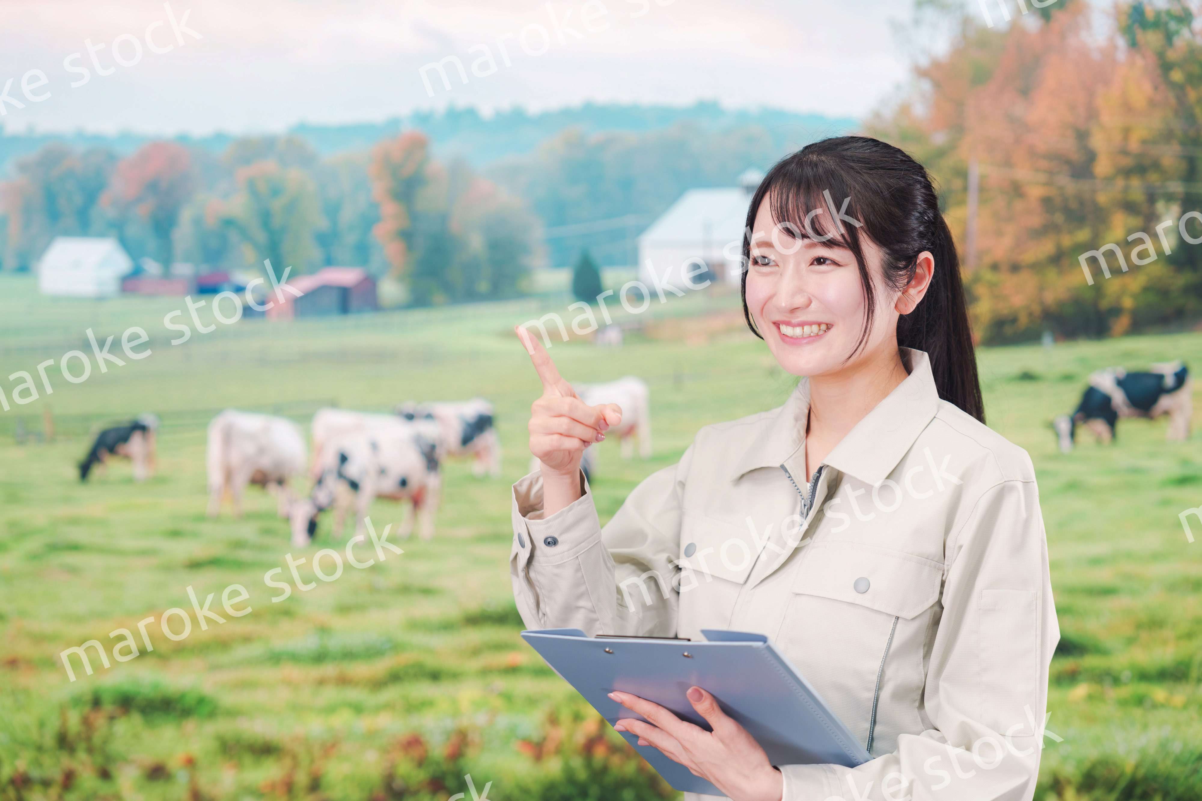牧場で働く作業服姿の若い女性