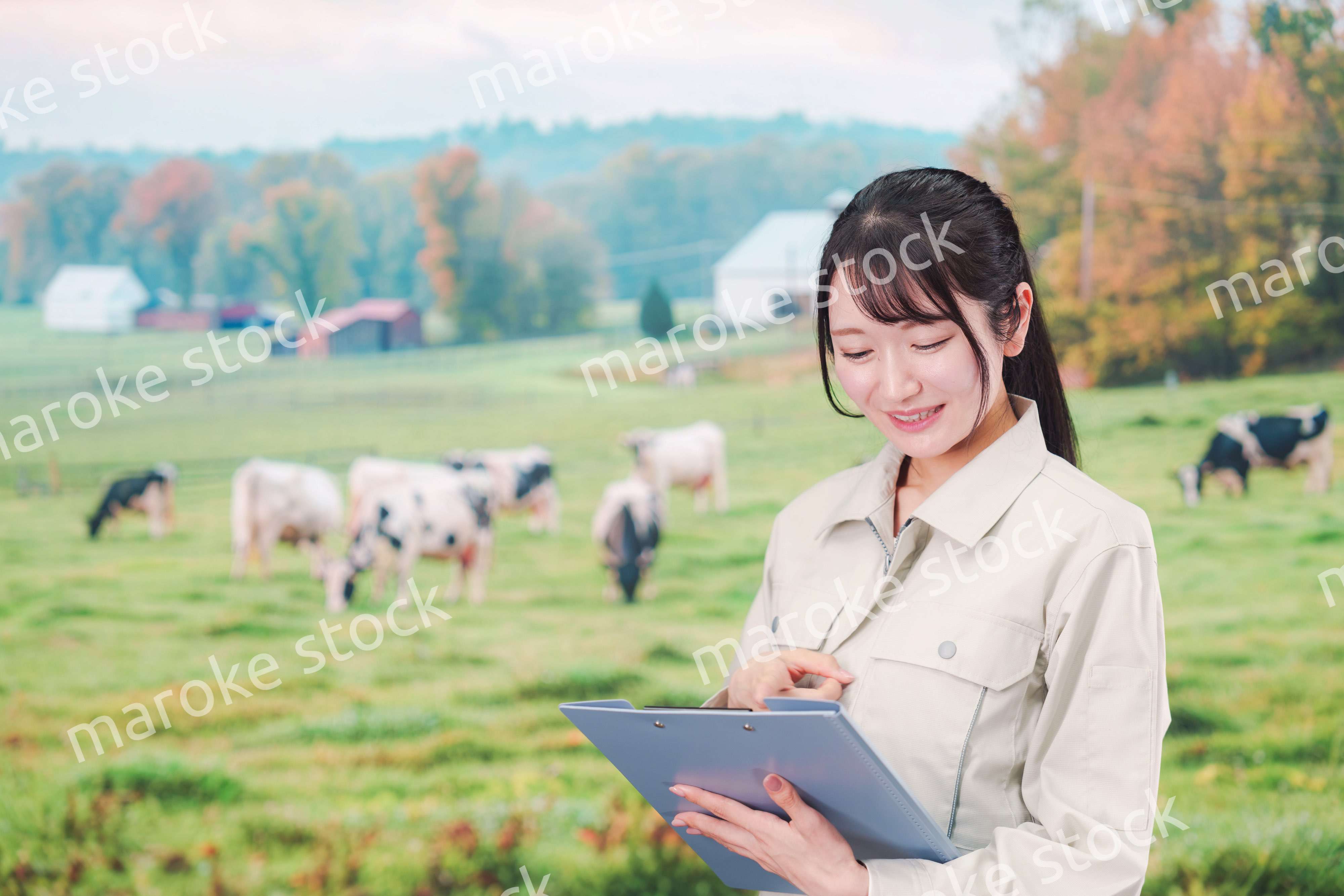 牧場で働く作業服姿の若い女性