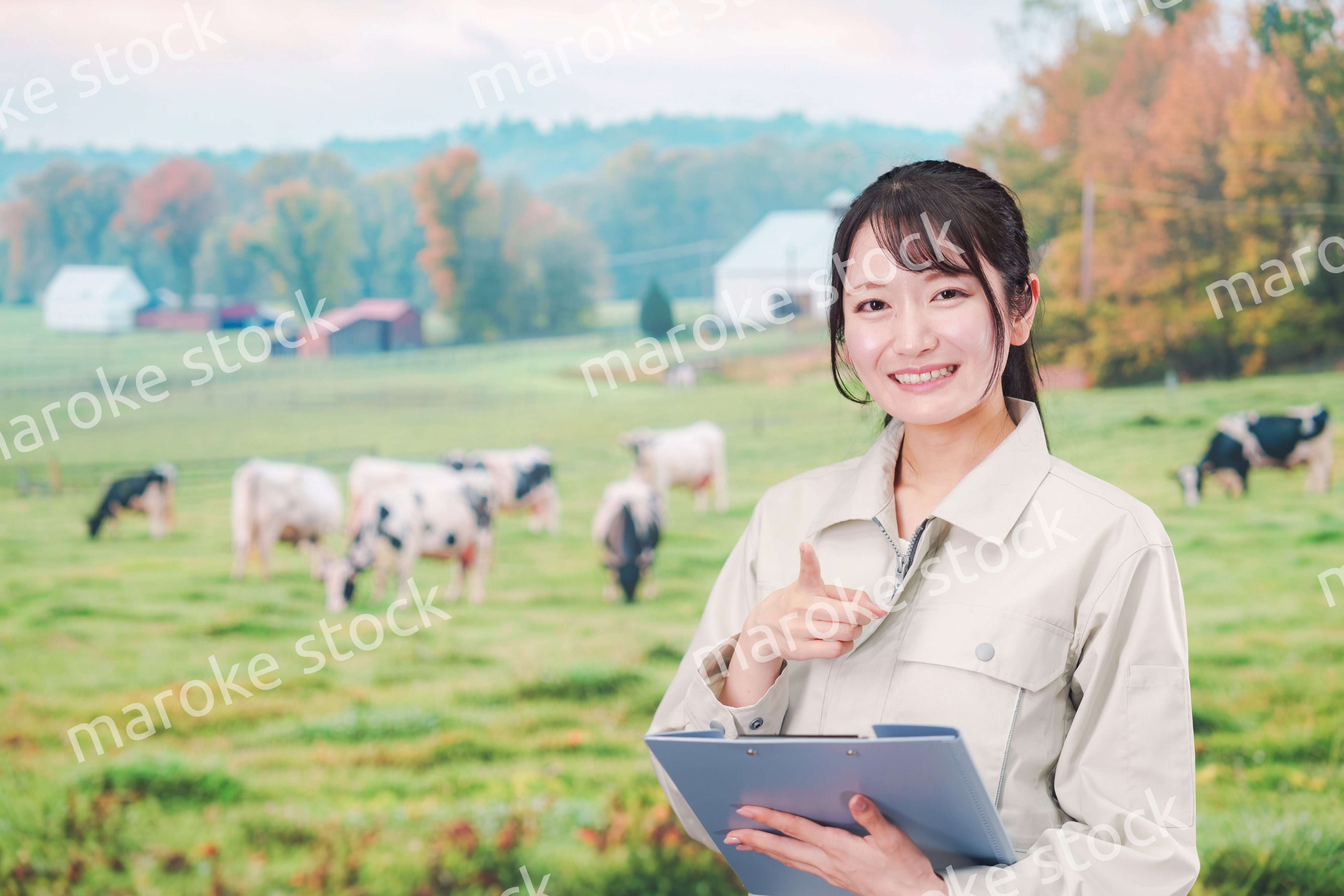 牧場で働く作業服姿の若い女性