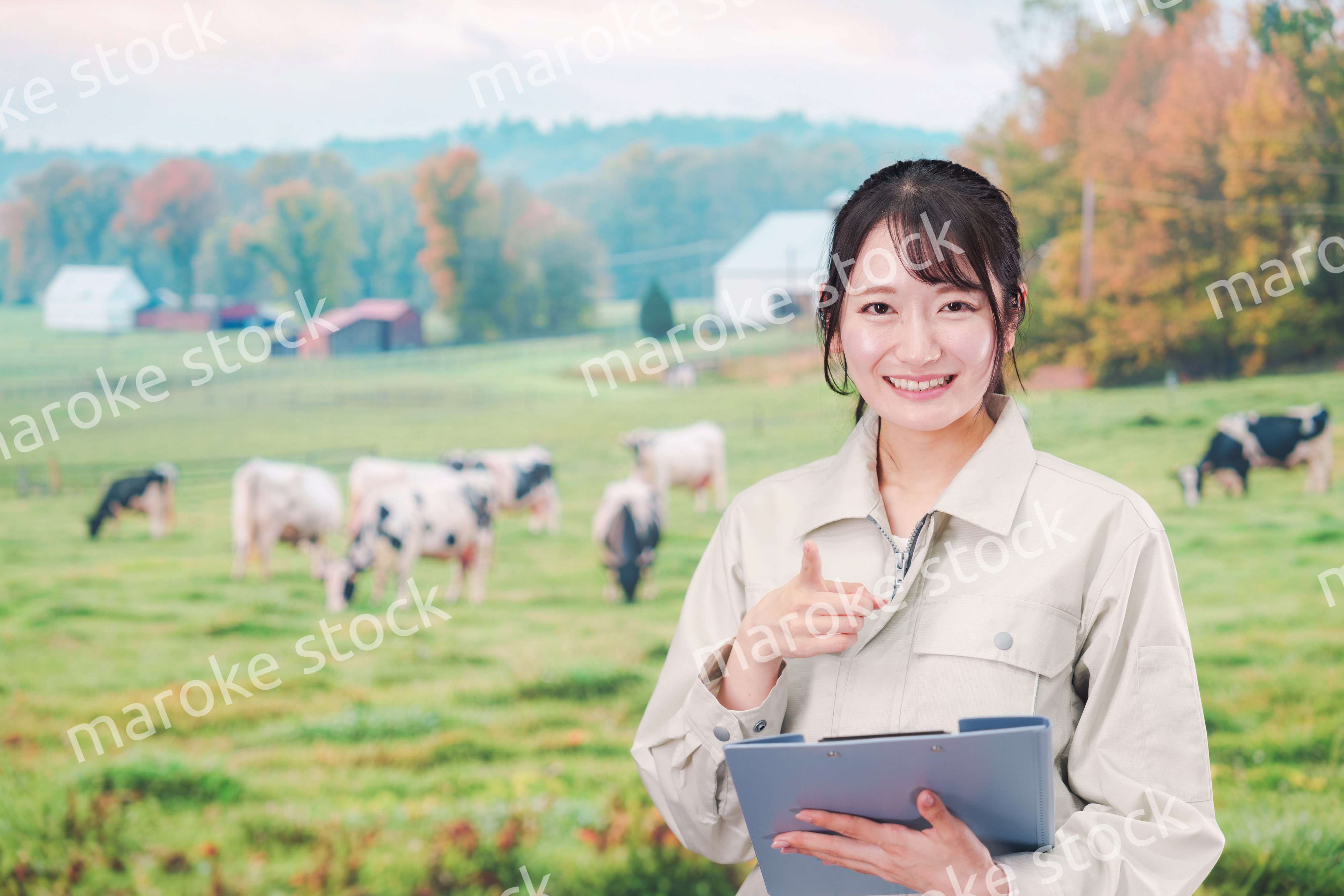 牧場で働く作業服姿の若い女性