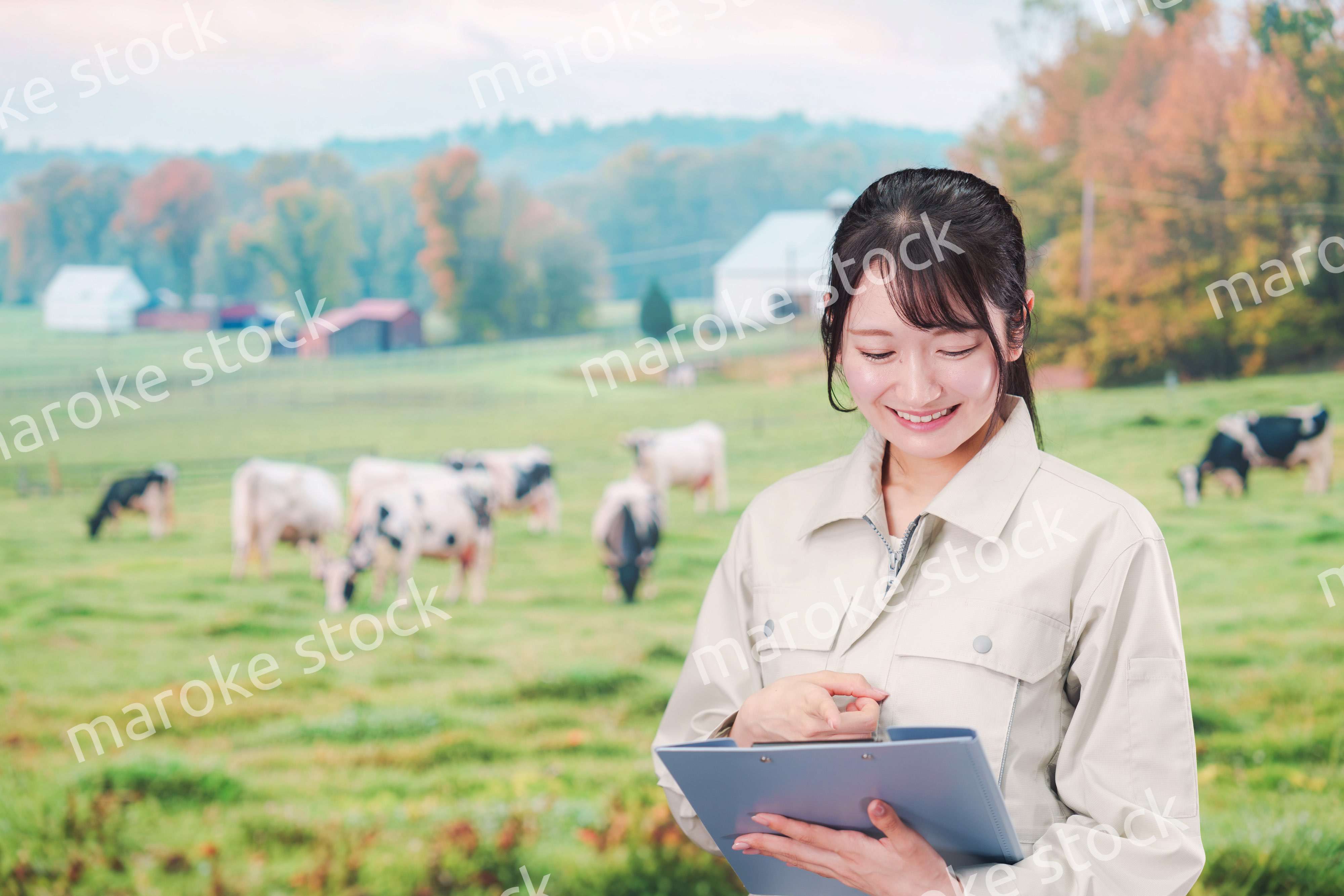 牧場で働く作業服姿の若い女性