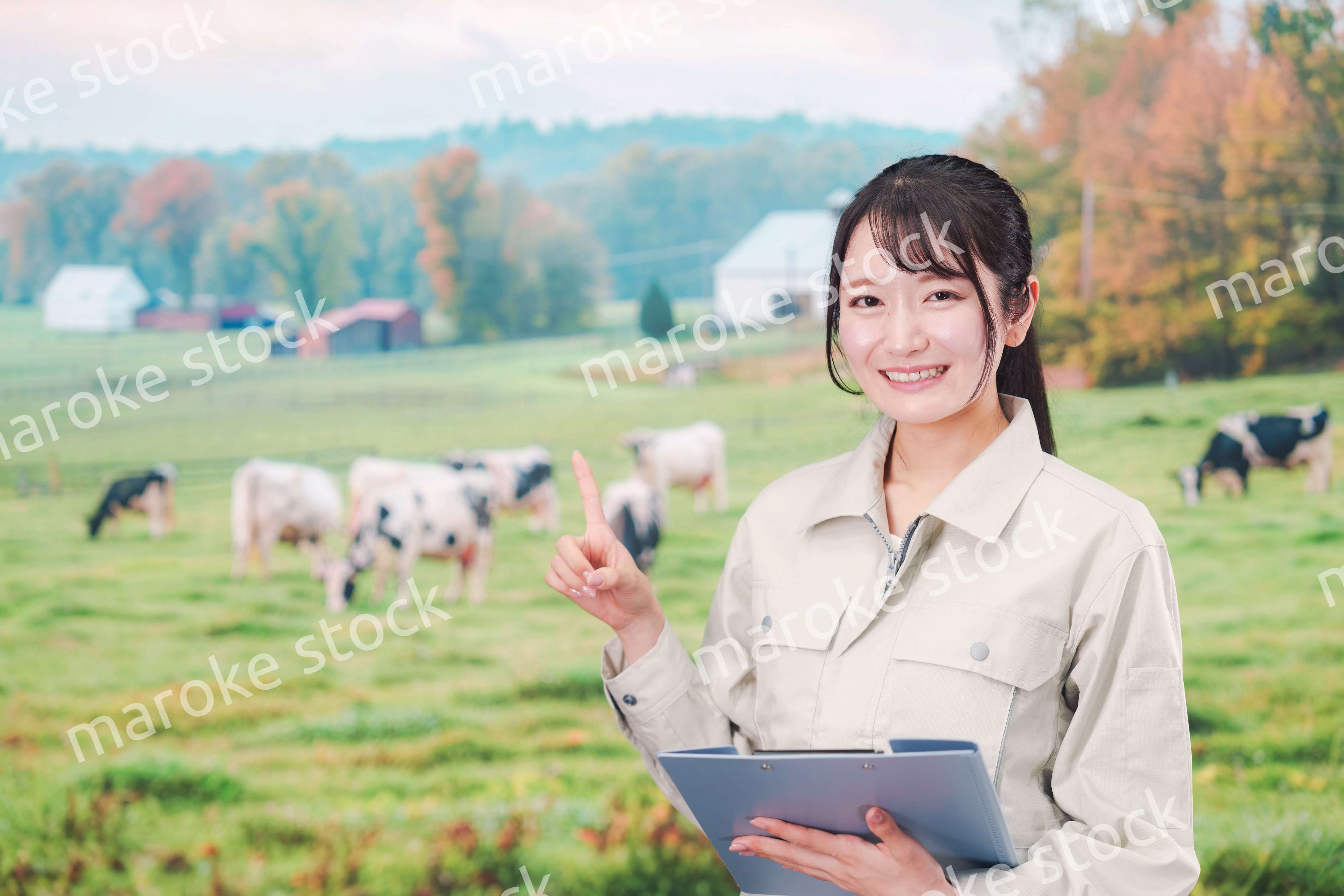 牧場で働く作業服姿の若い女性