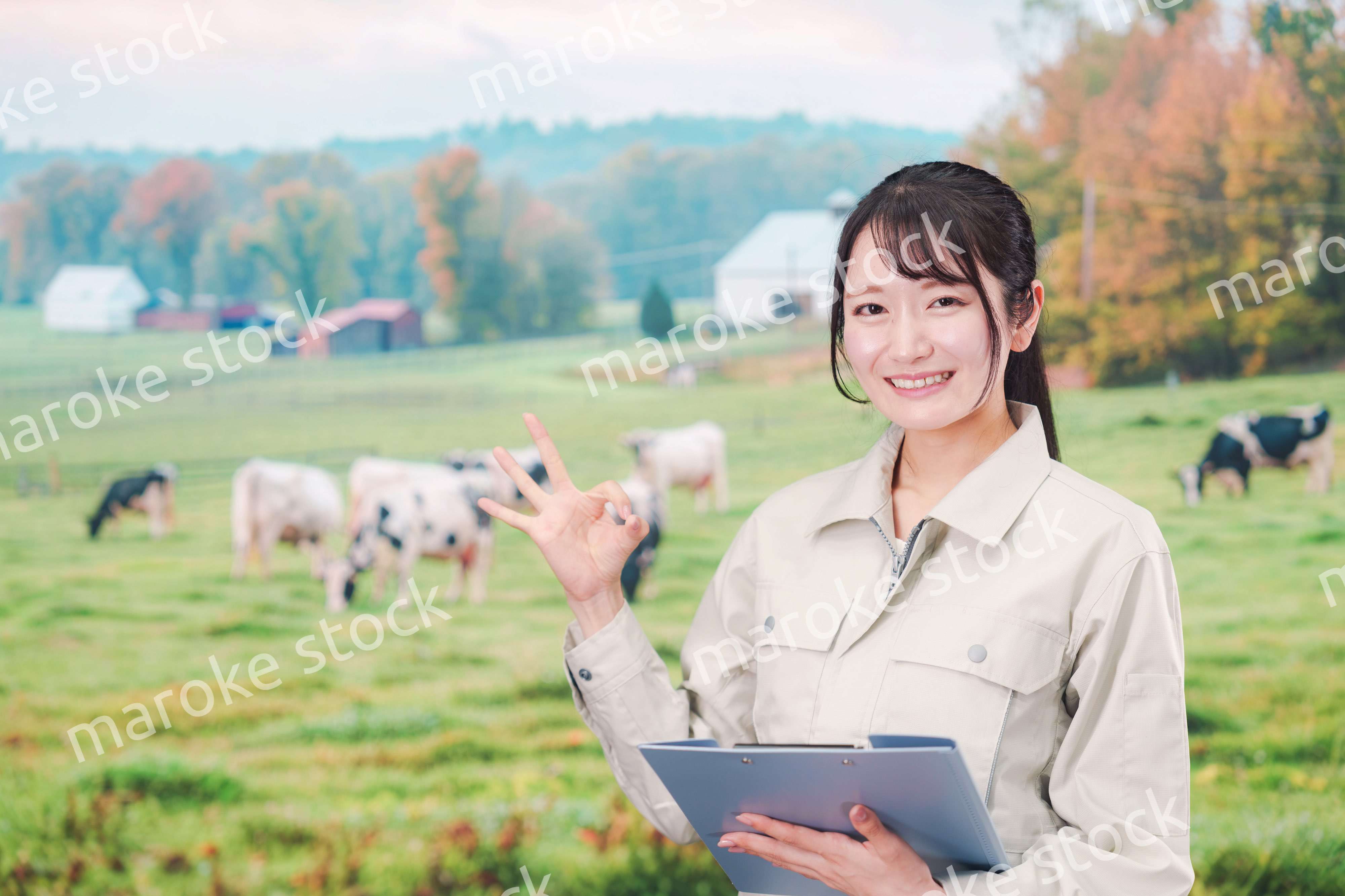 牧場で働く作業服姿の若い女性