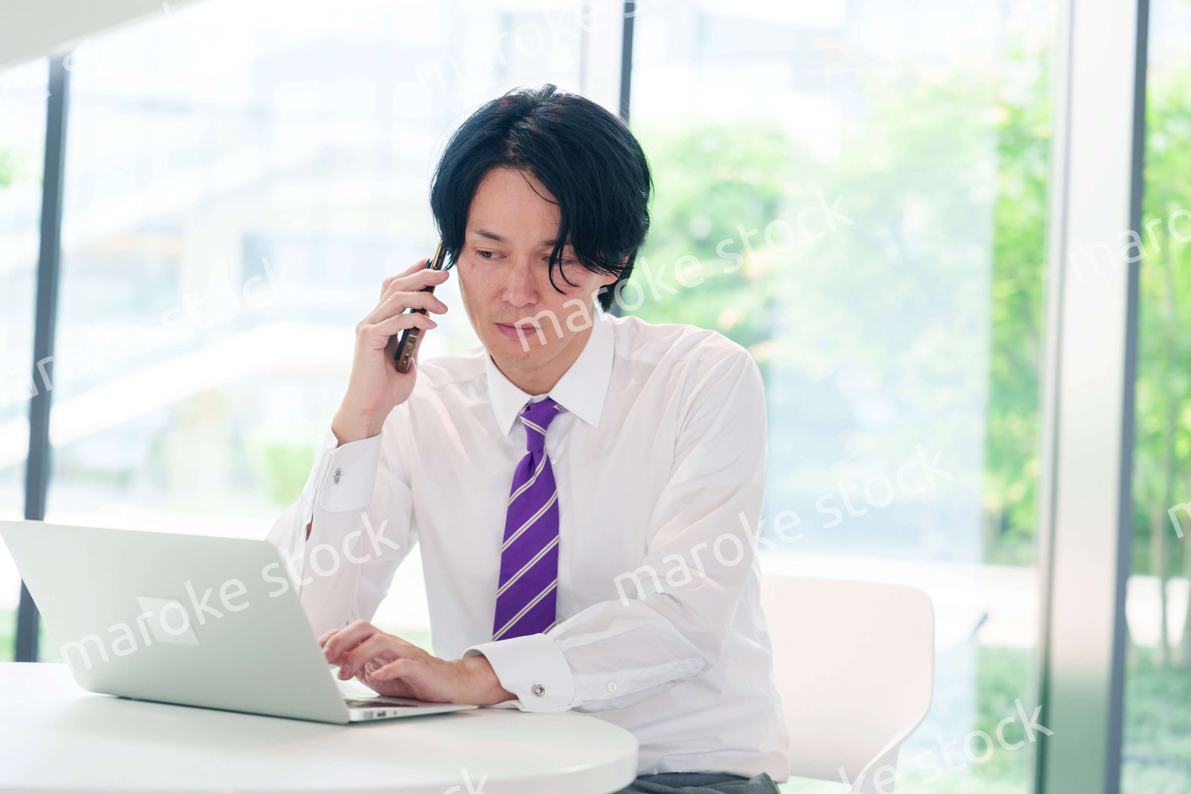 不機嫌な表情で電話をするビジネスマン