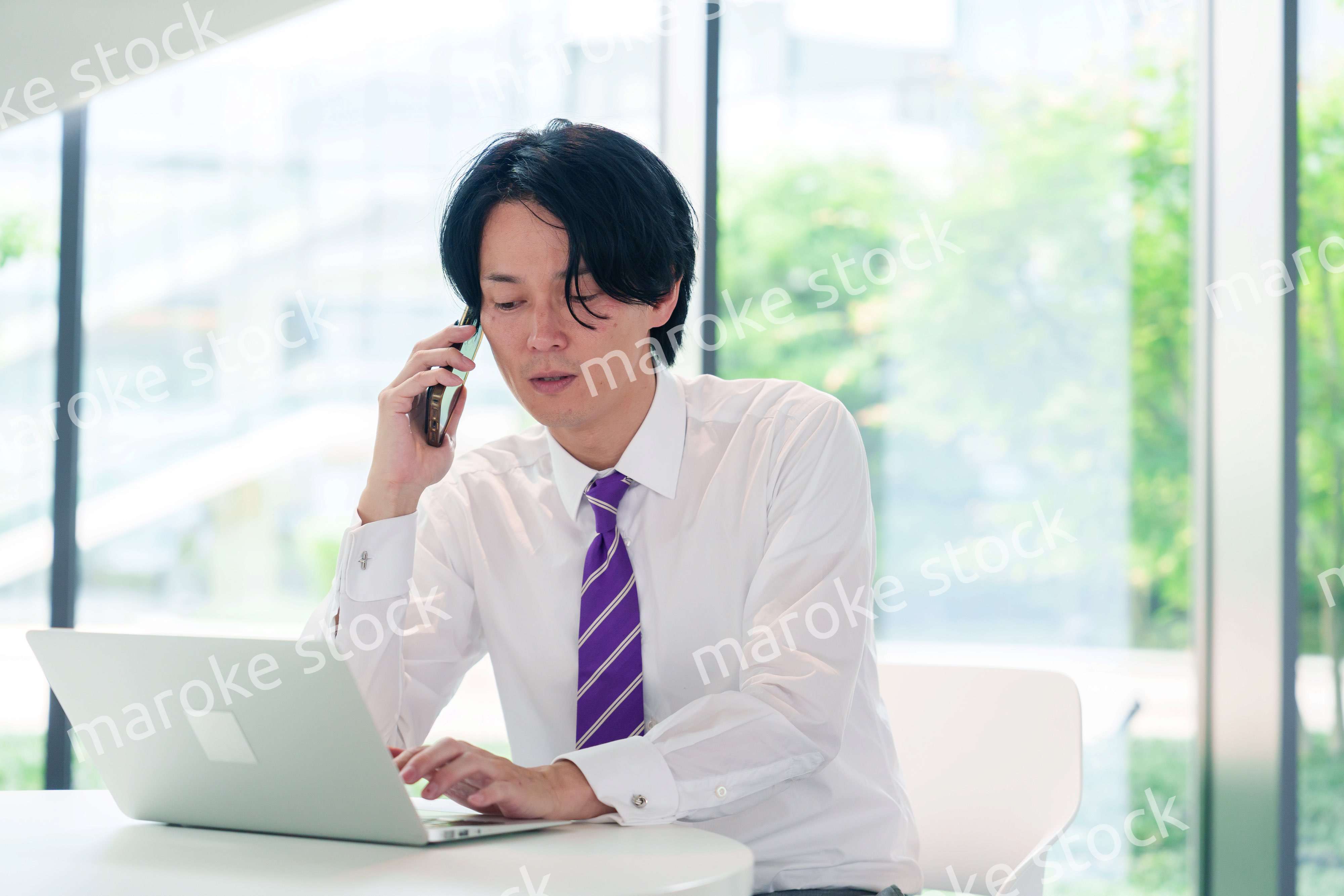 不機嫌な表情で電話をするビジネスマン