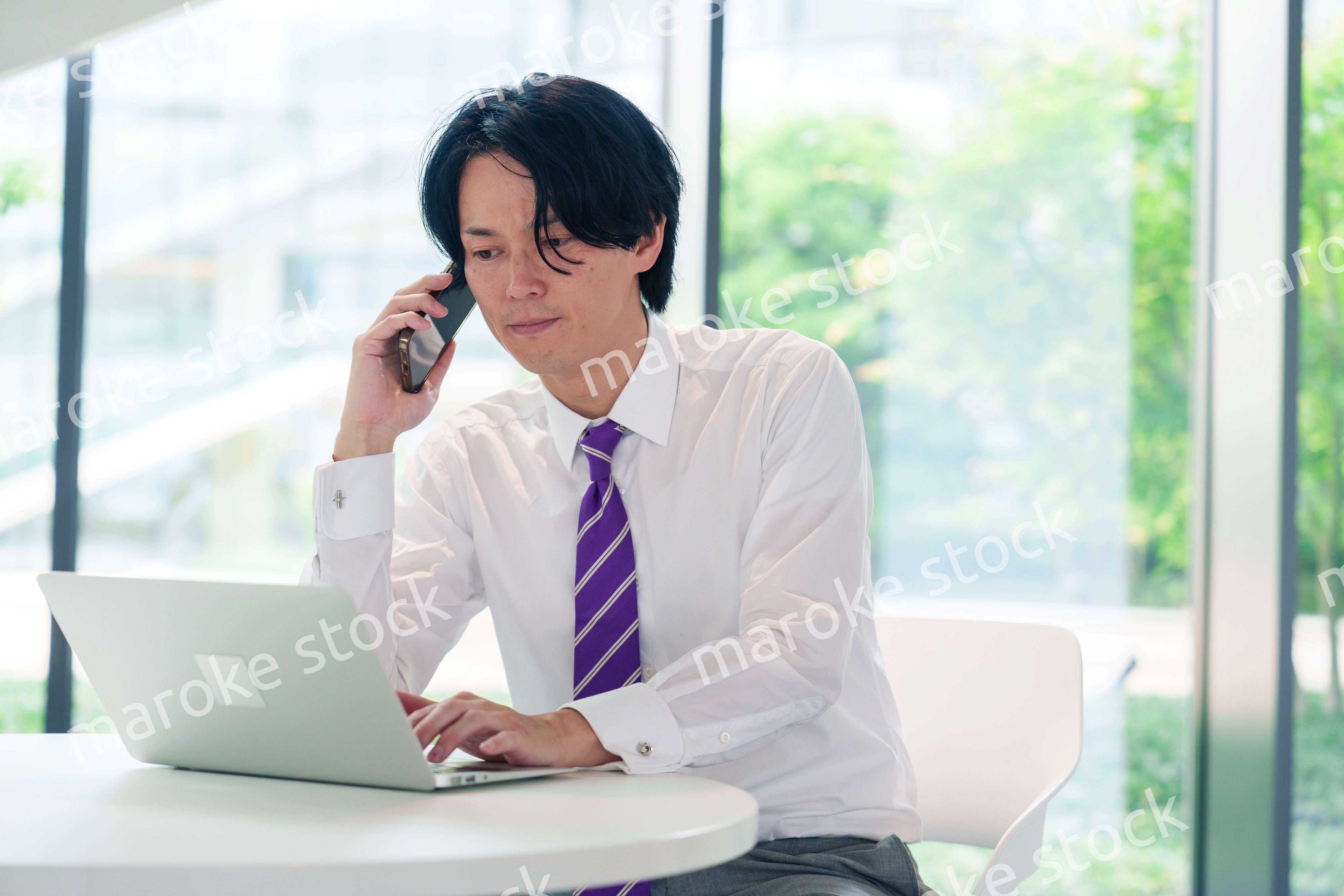 不機嫌な表情で電話をするビジネスマン