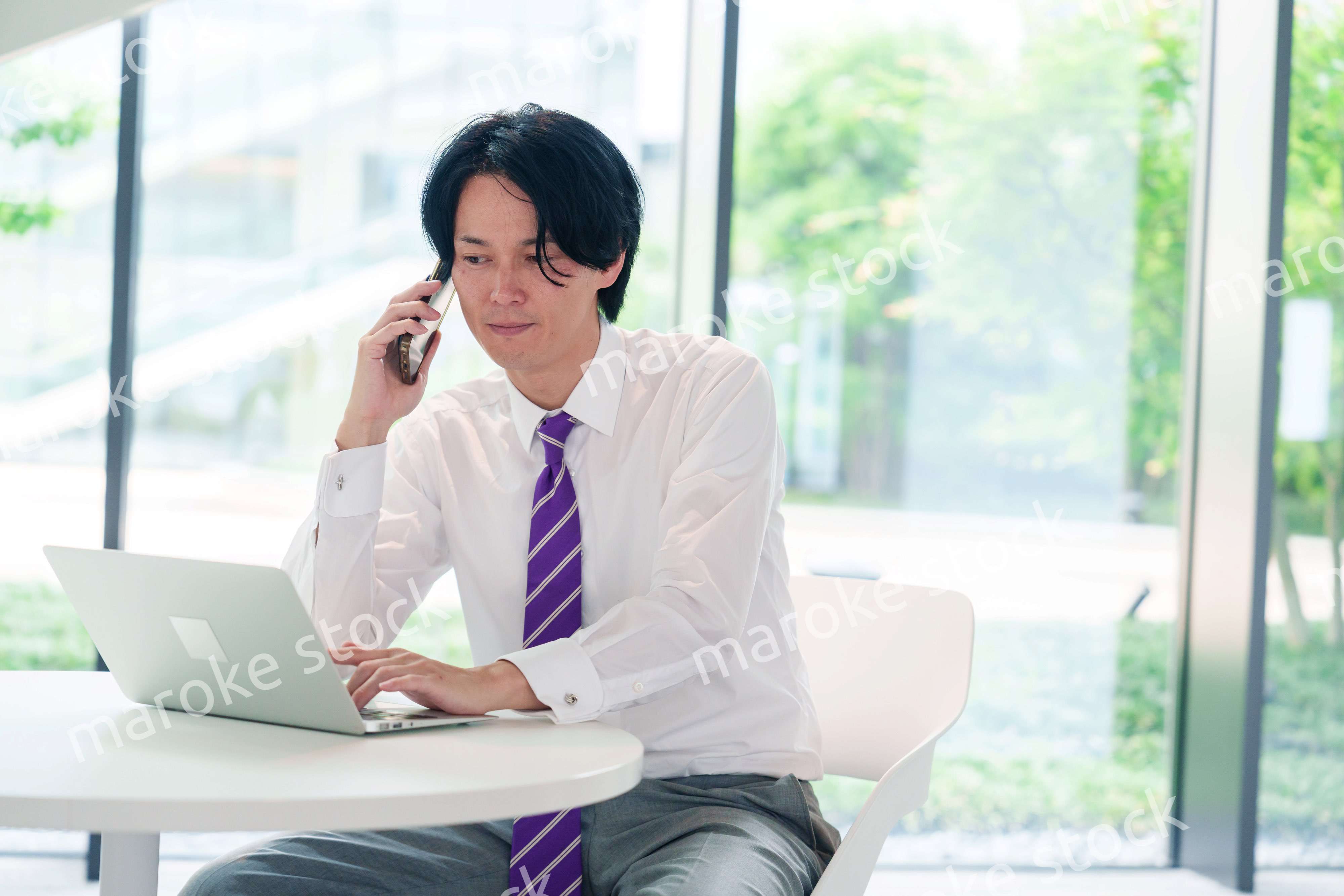 不機嫌な表情で電話をするビジネスマン