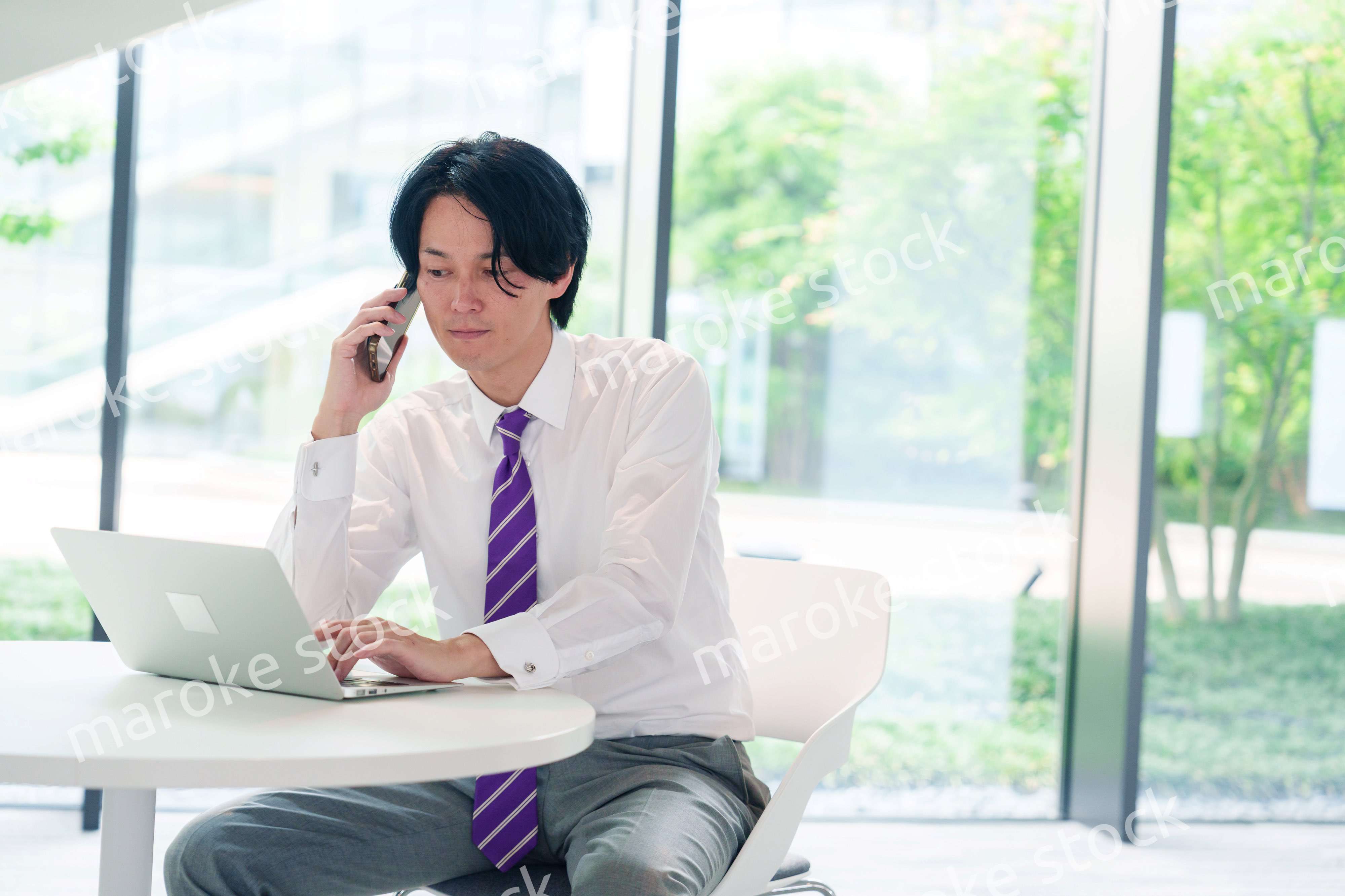 不機嫌な表情で電話をするビジネスマン