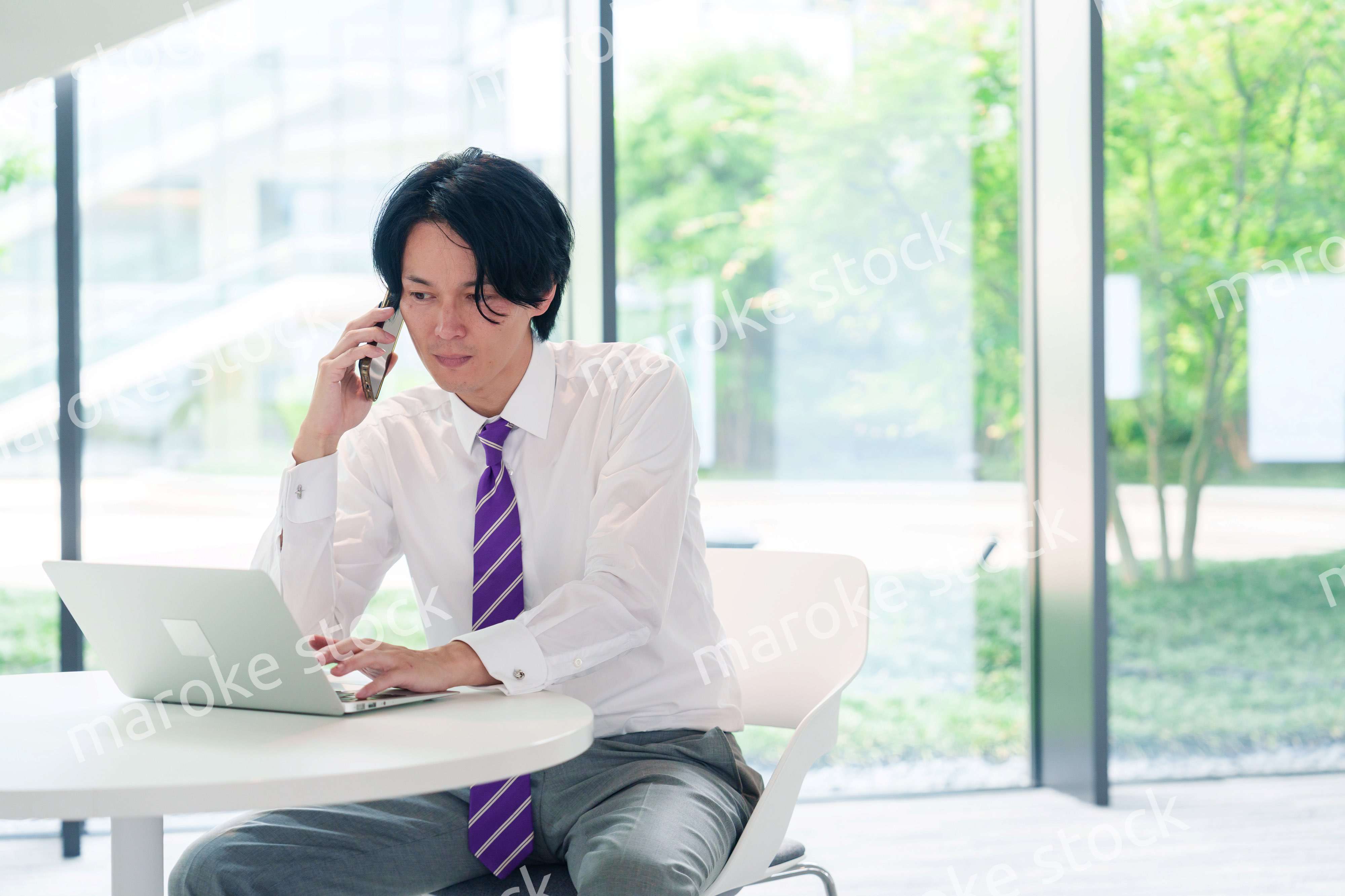 不機嫌な表情で電話をするビジネスマン