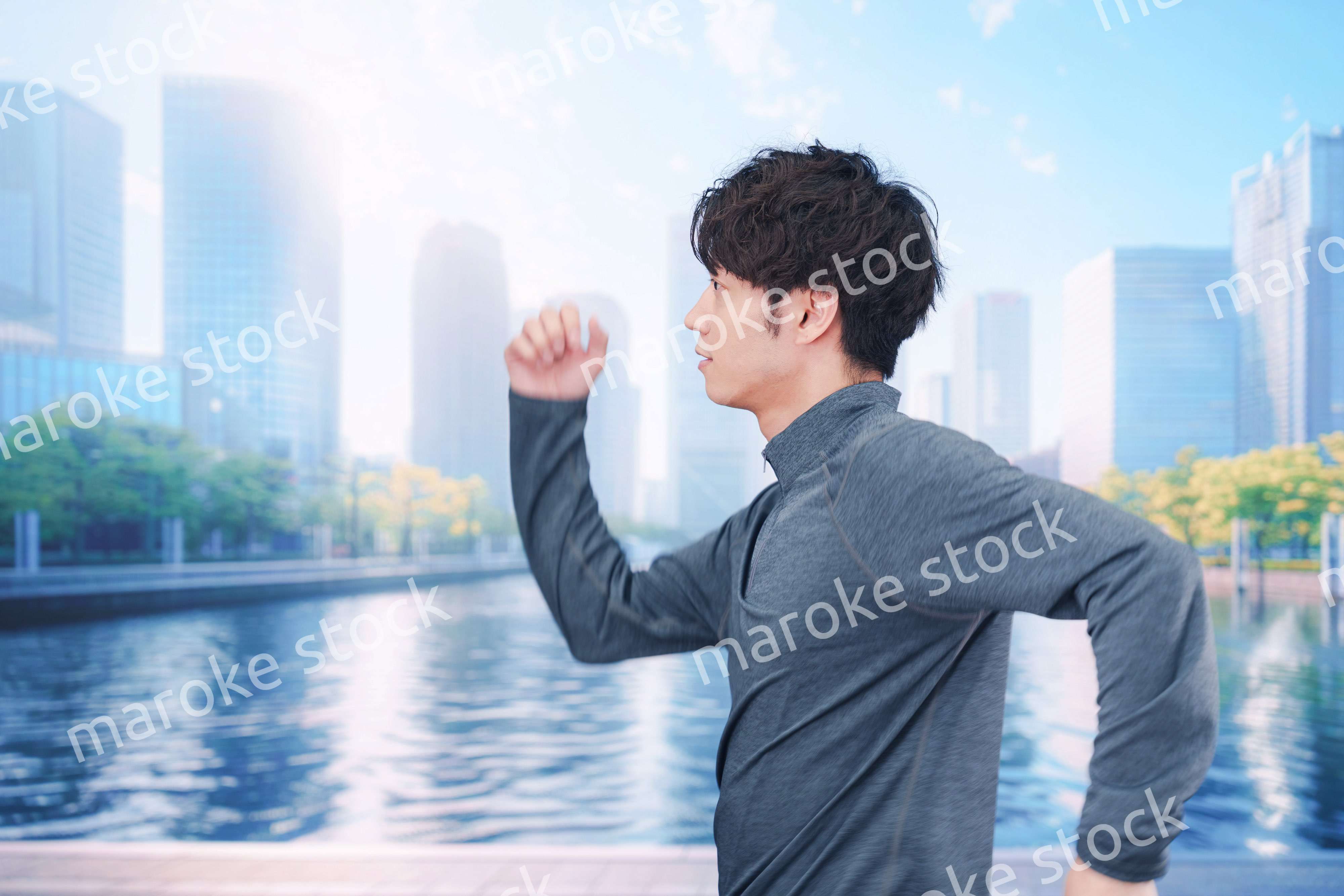 お昼の都会でランニングをする若い男性