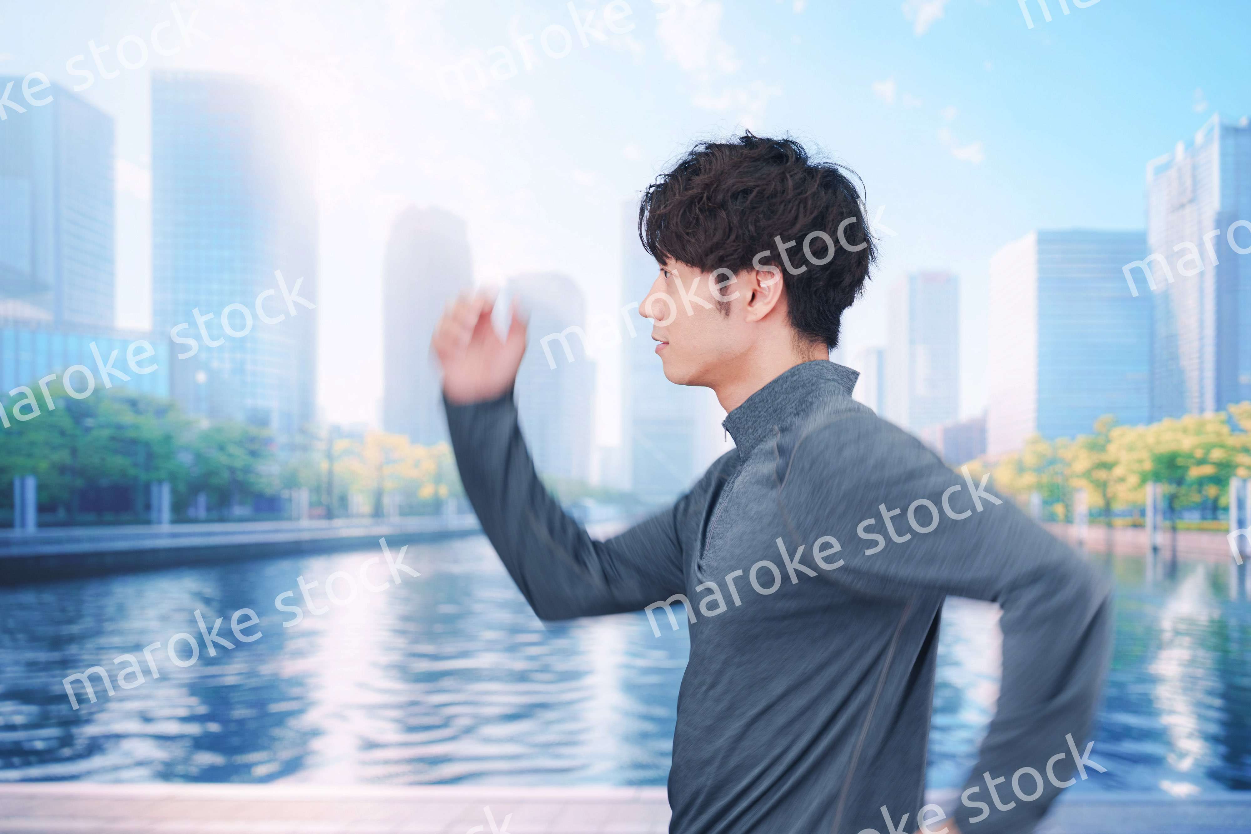 お昼の都会でランニングをする若い男性