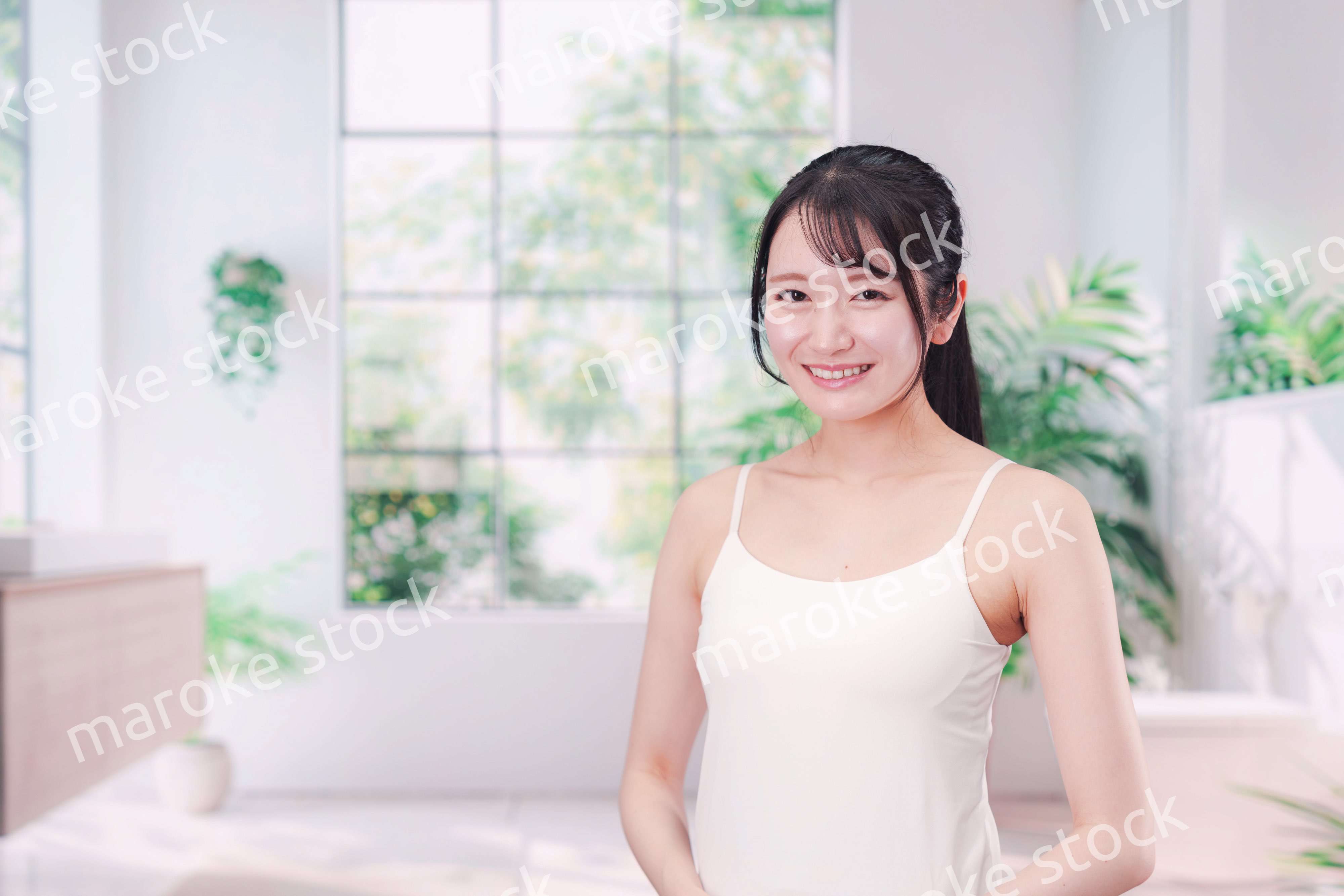 笑顔でビューティーケアをする若い女性