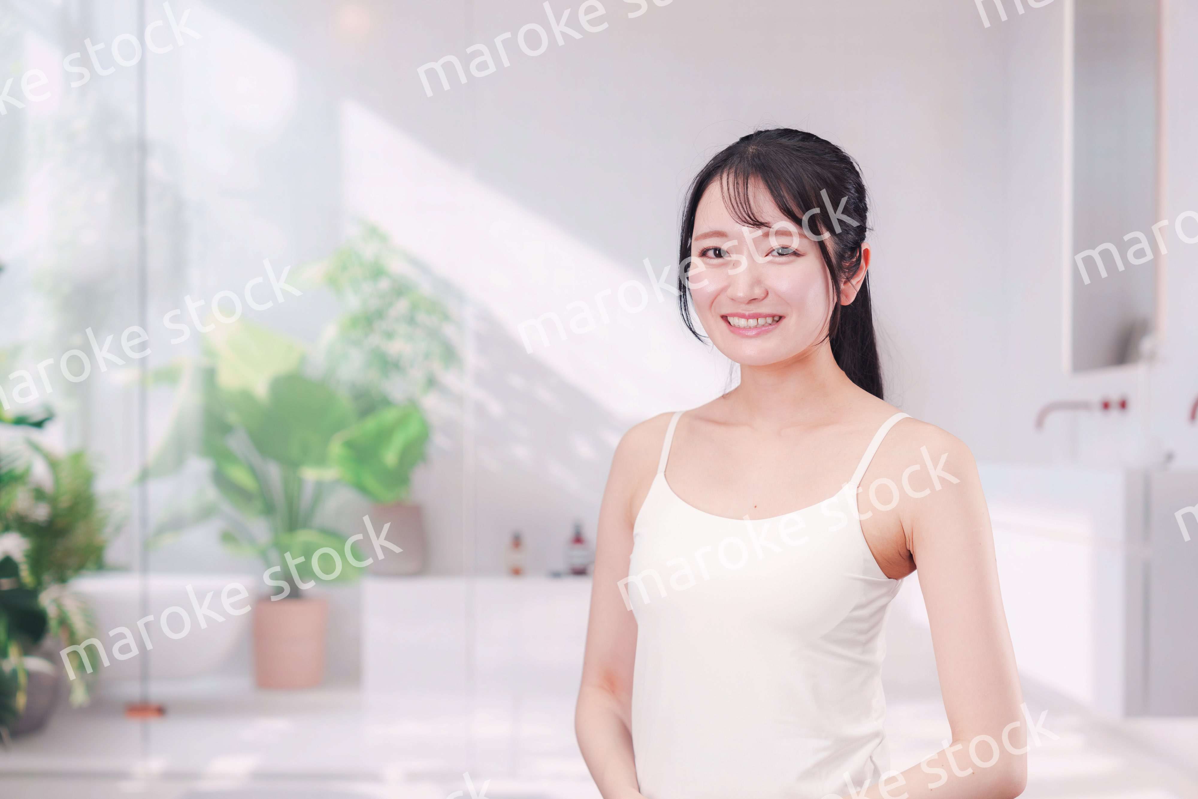 笑顔でビューティーケアをする若い女性