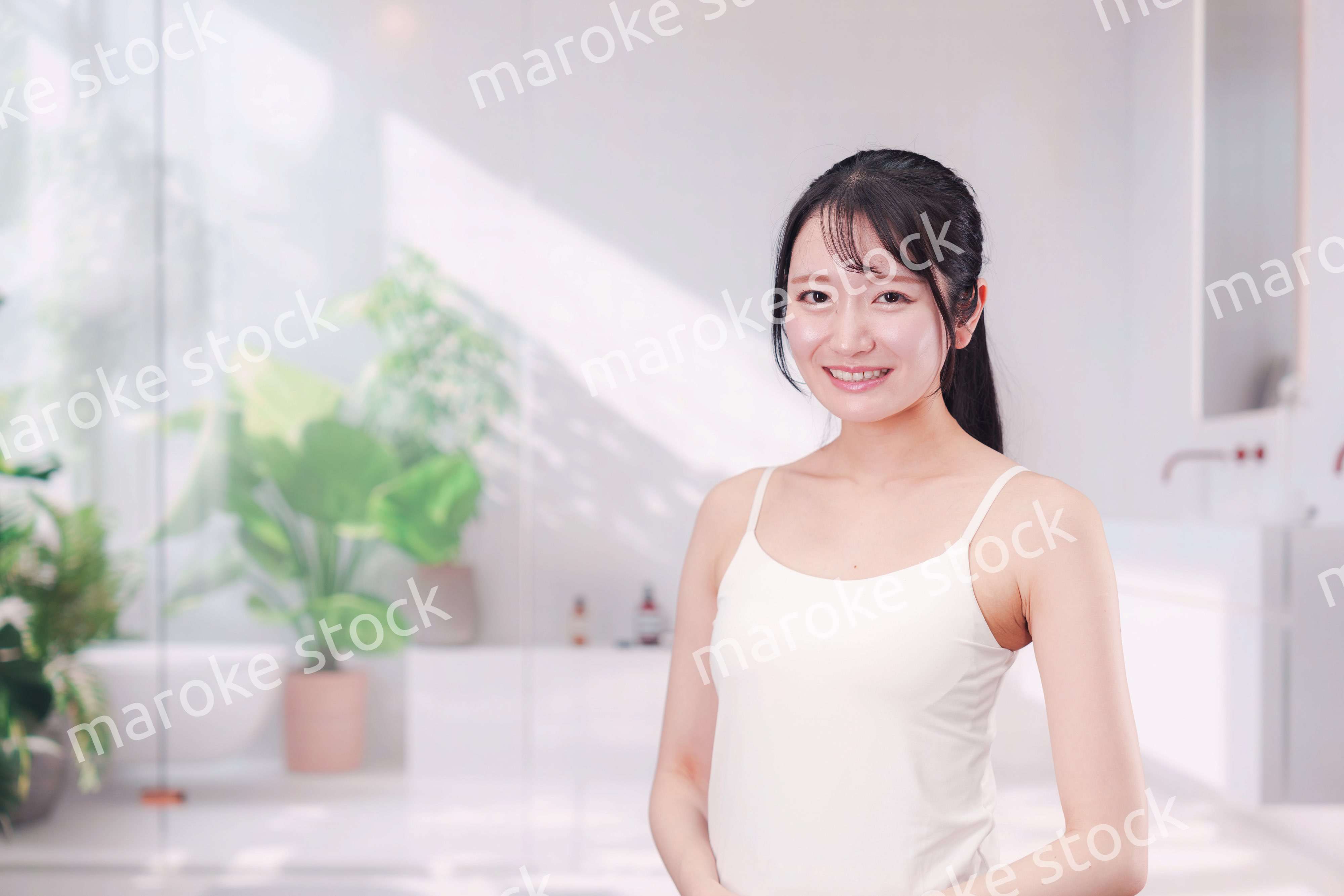 笑顔でビューティーケアをする若い女性