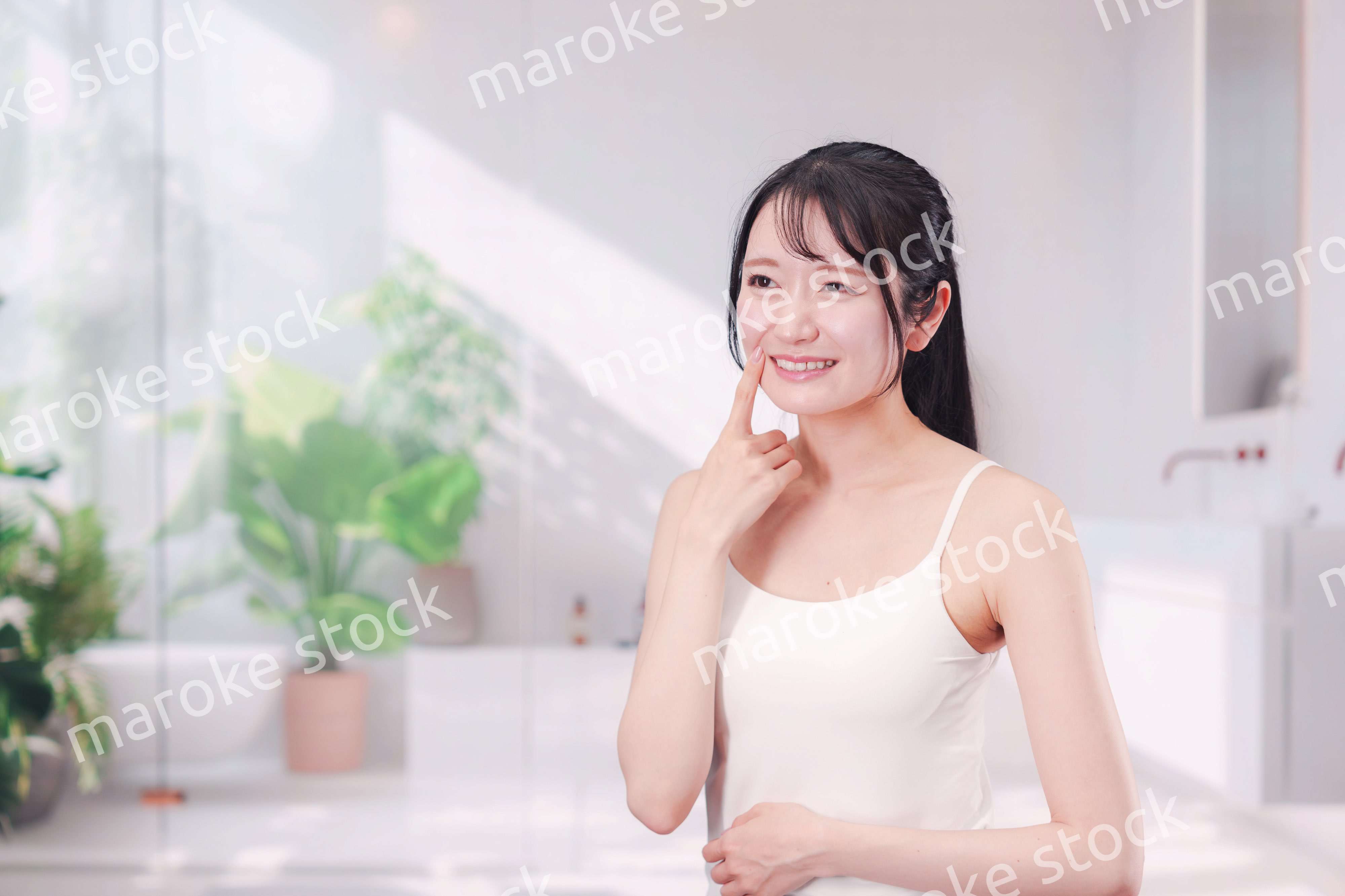 笑顔でビューティーケアをする若い女性