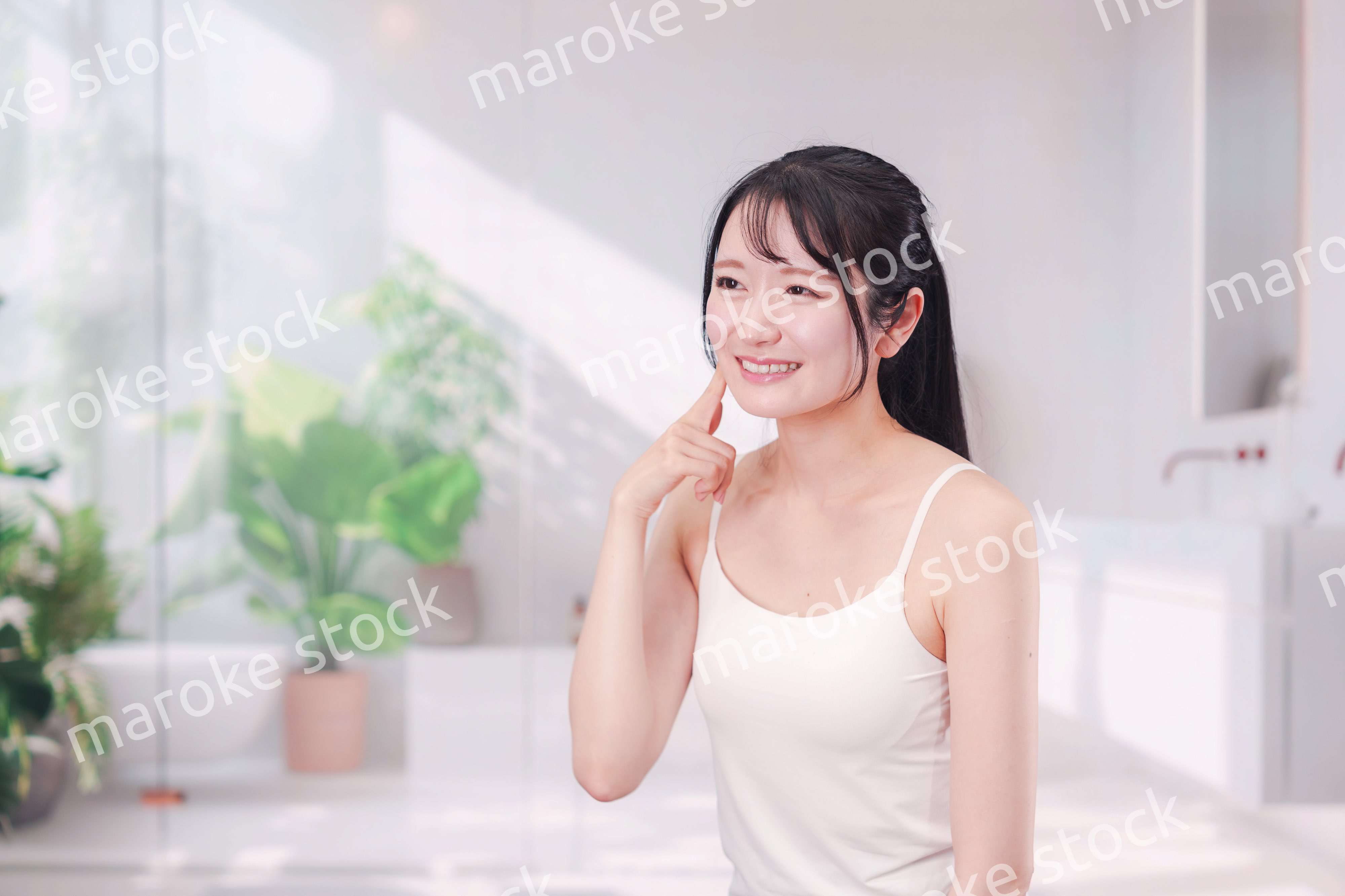 笑顔でビューティーケアをする若い女性