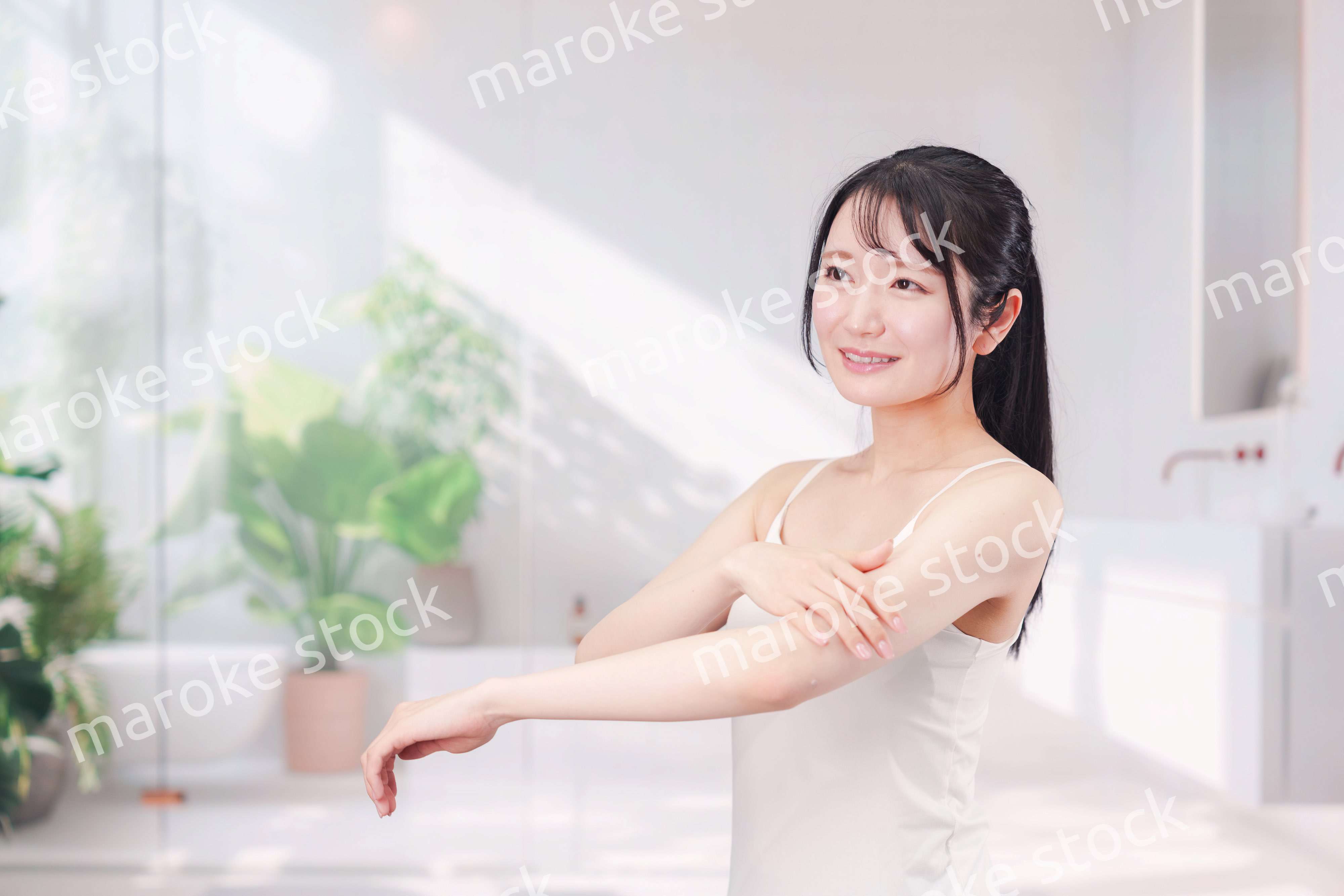 腕にクリームを塗る若い女性