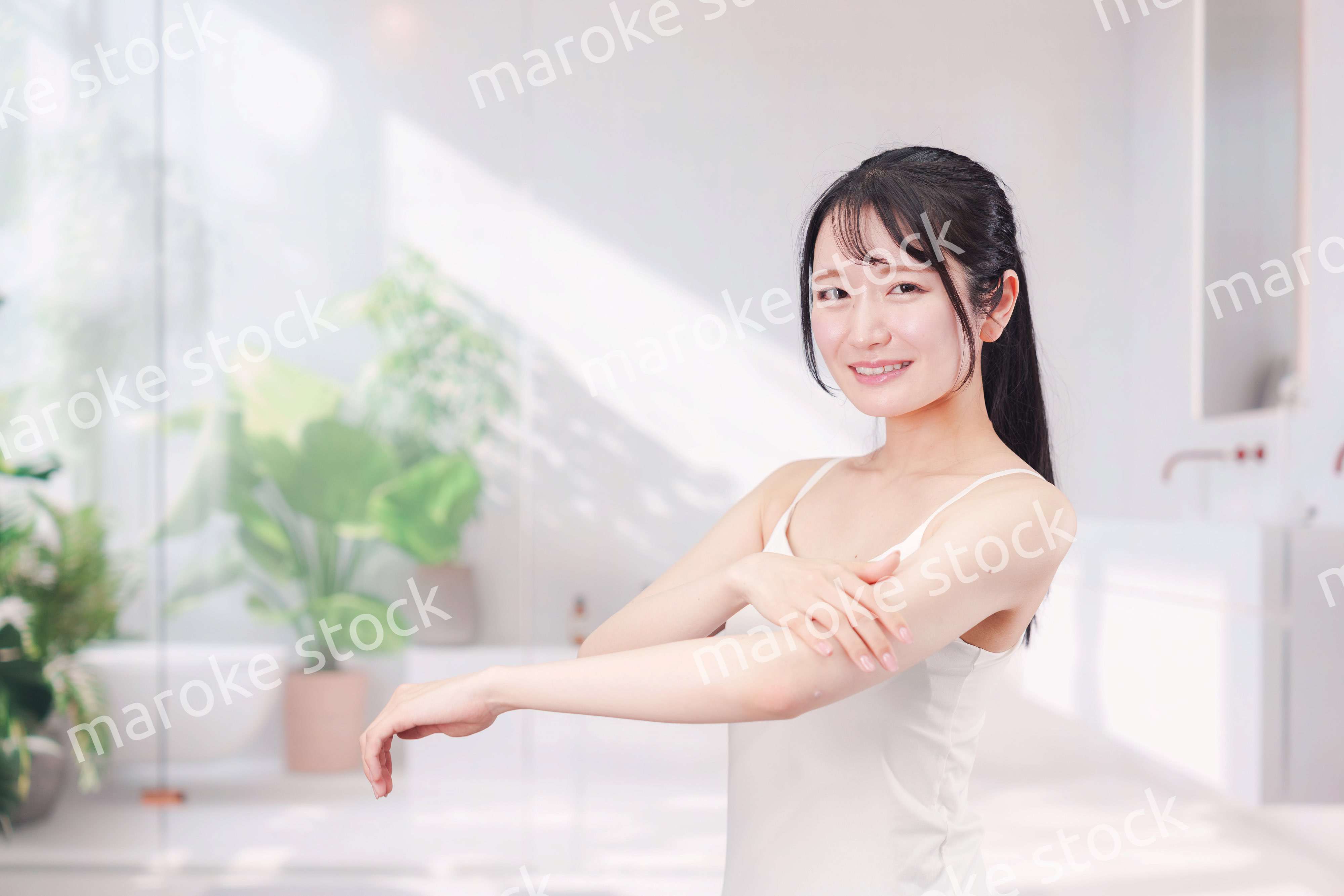 腕にクリームを塗る若い女性