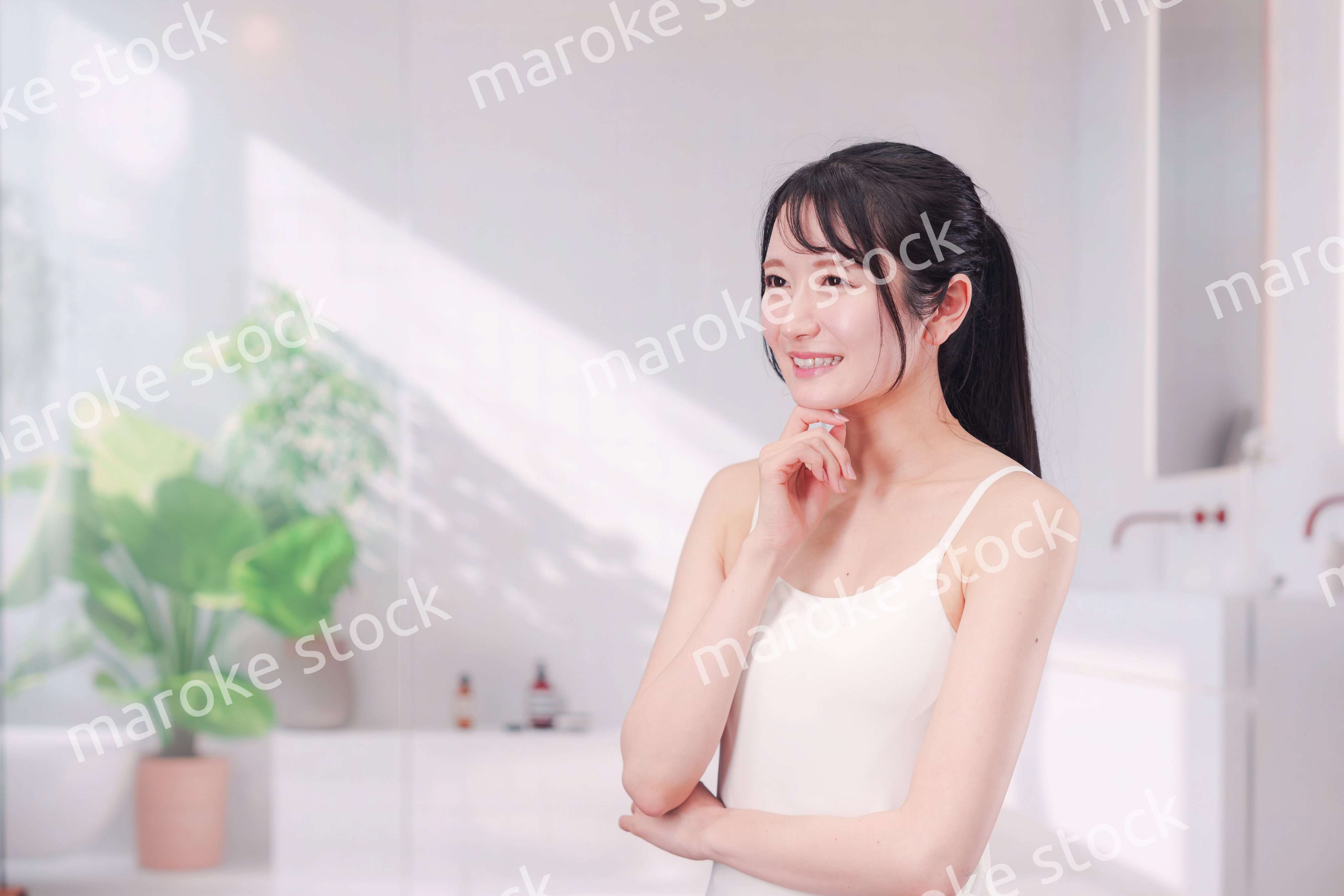 笑顔でビューティーケアをする若い女性