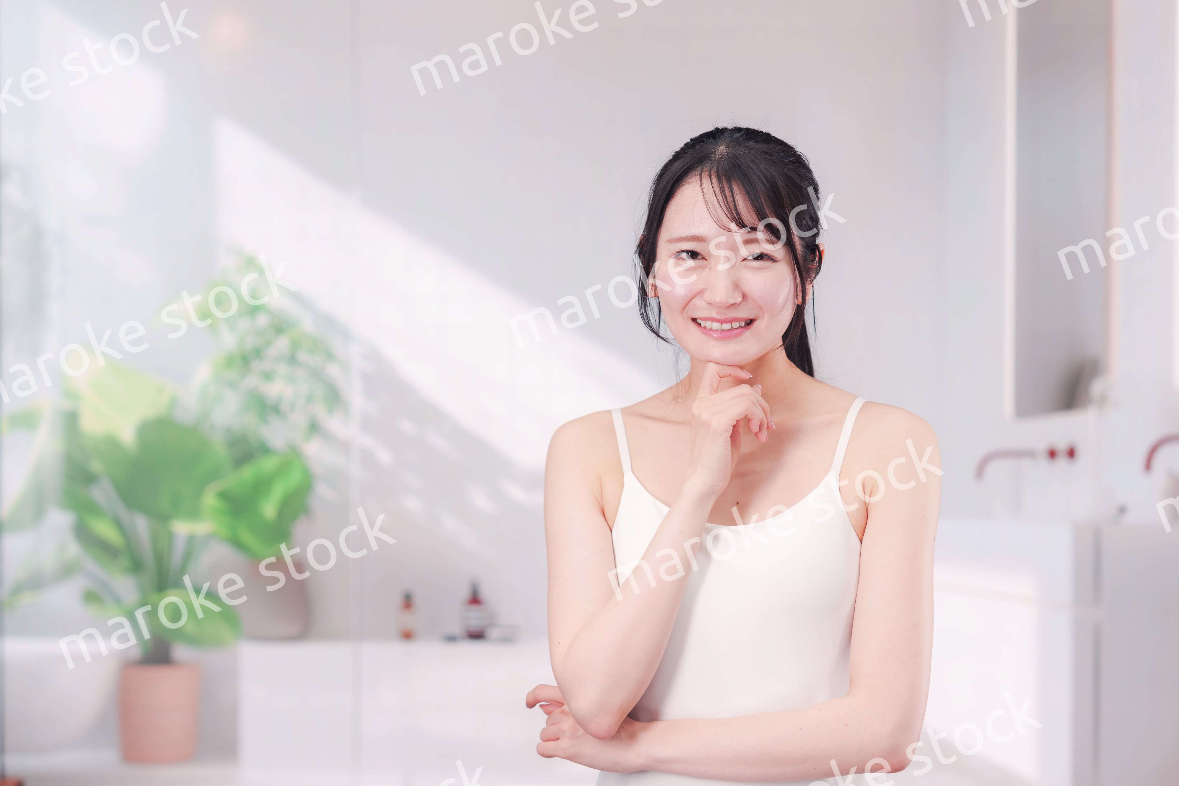 笑顔でビューティーケアをする若い女性