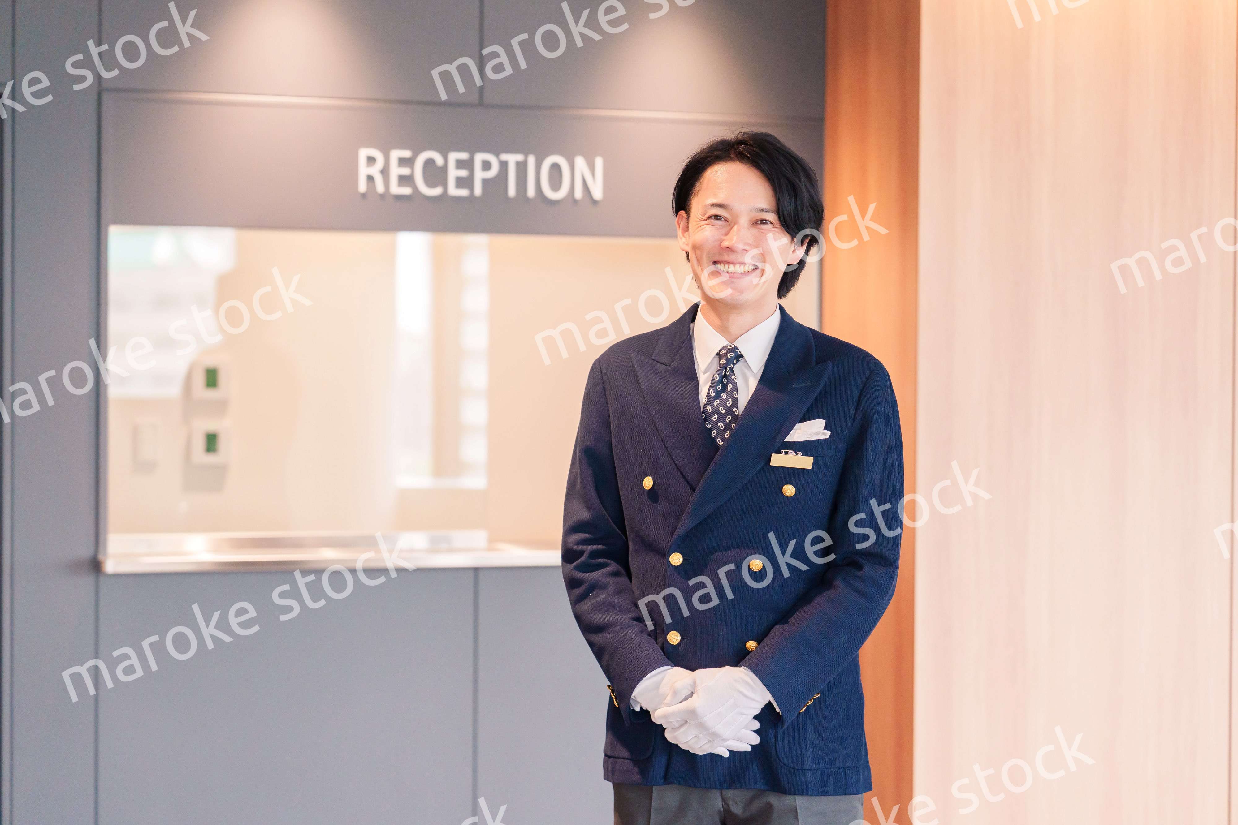 笑顔で接客をするホテルマンの男性