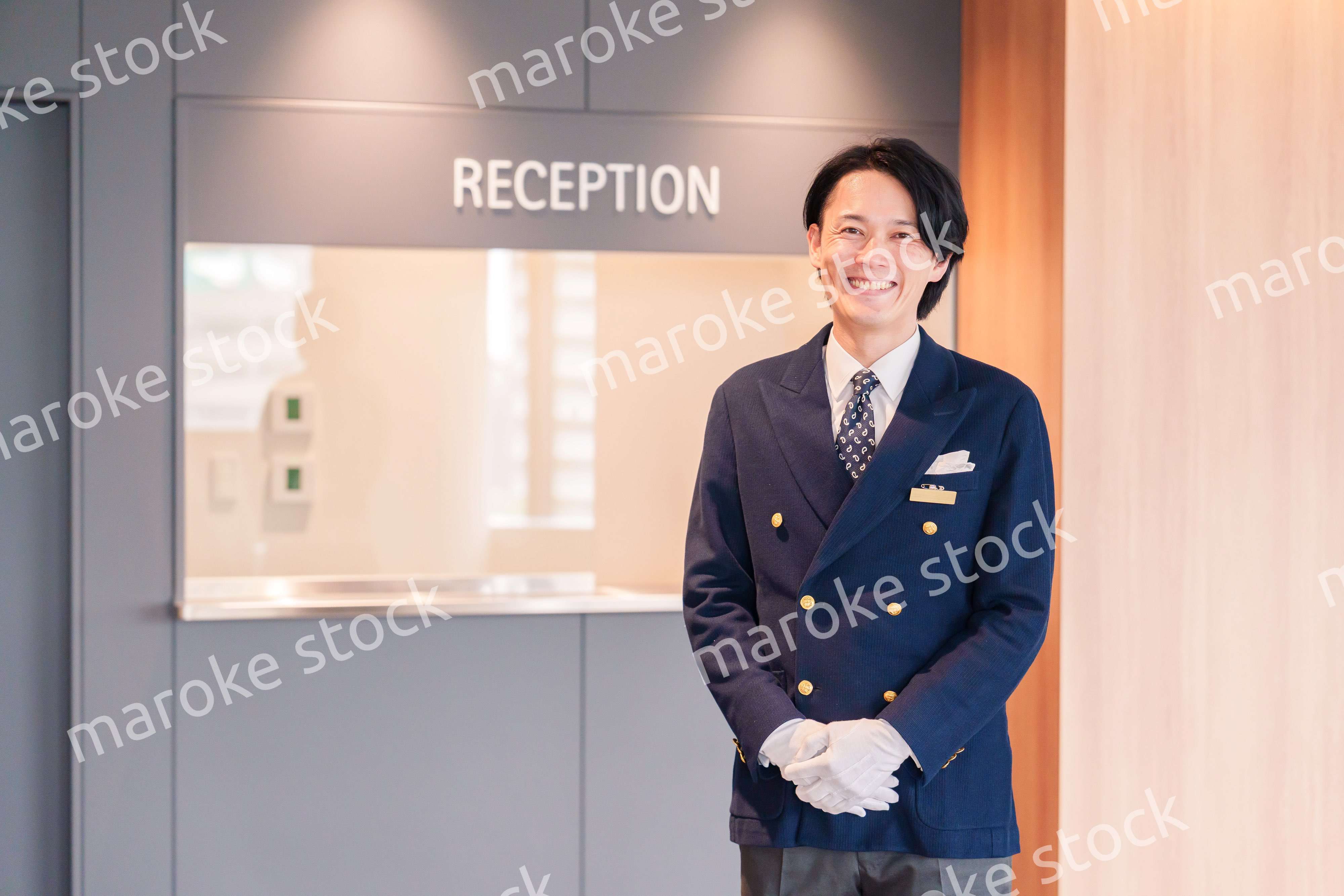 笑顔で接客をするホテルマンの男性
